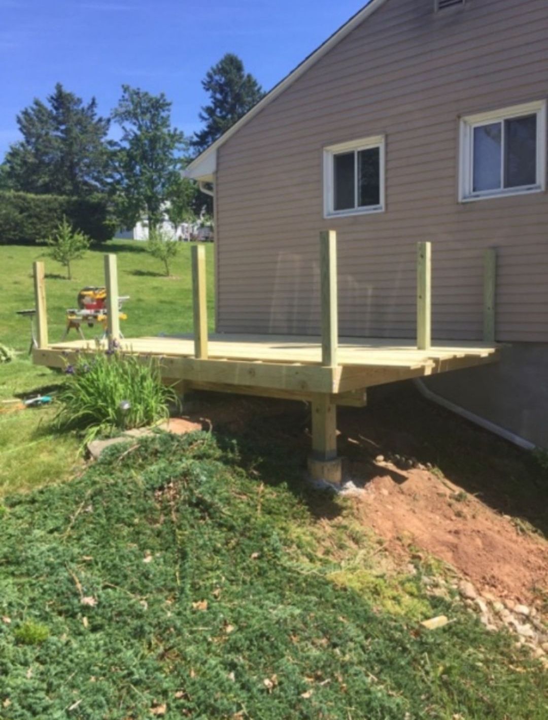 A wooden deck is being built in front of a house.