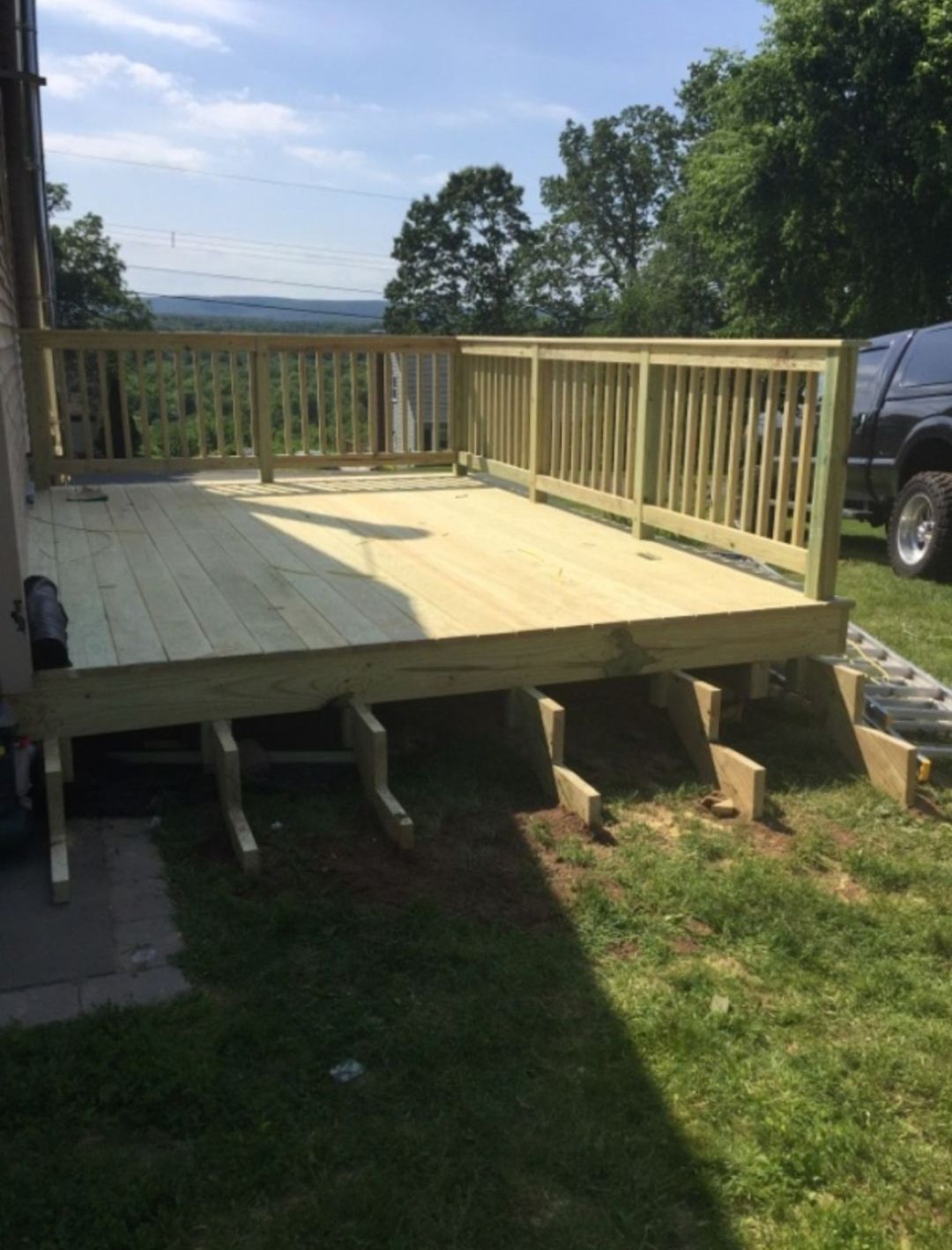 A wooden deck is being built in the backyard of a house.
