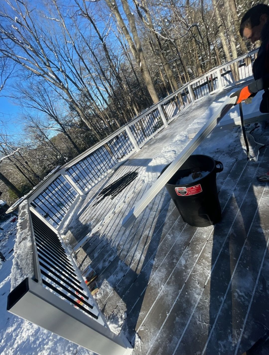 A person is working on a deck in the snow.
