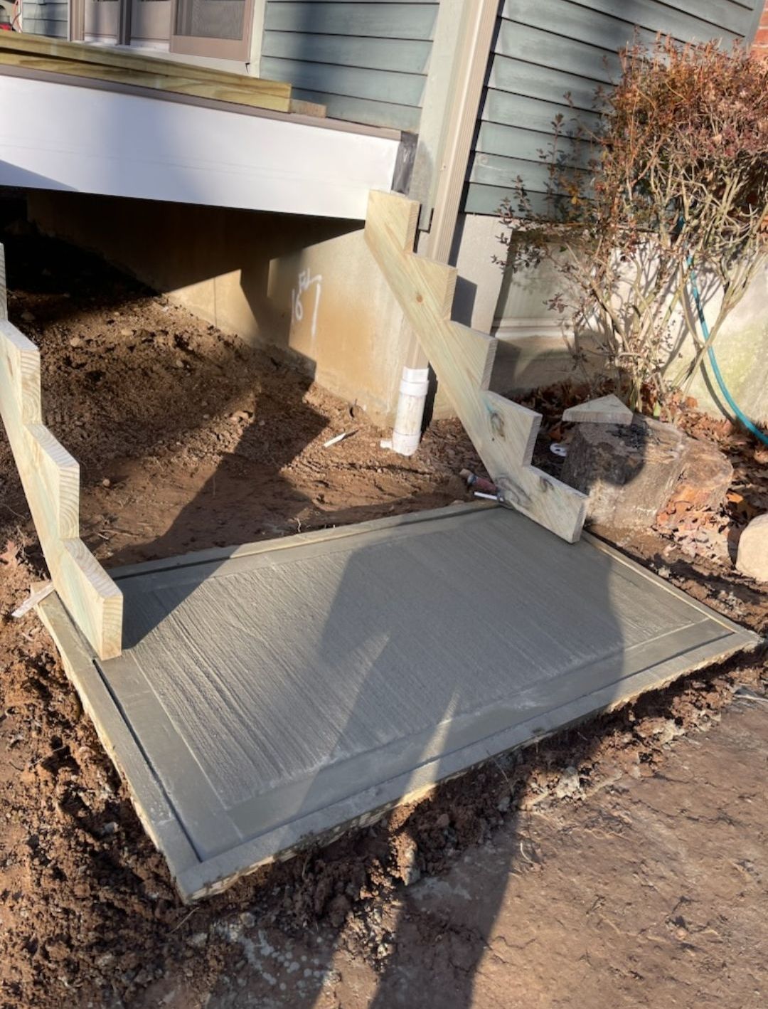A concrete ramp is being built in front of a house.