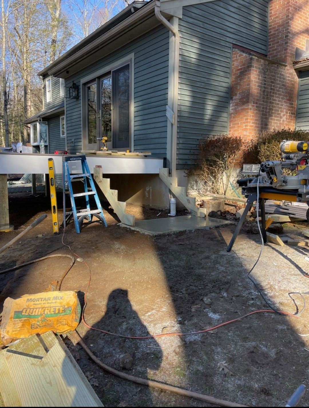 A ladder is sitting on the ground in front of a house.