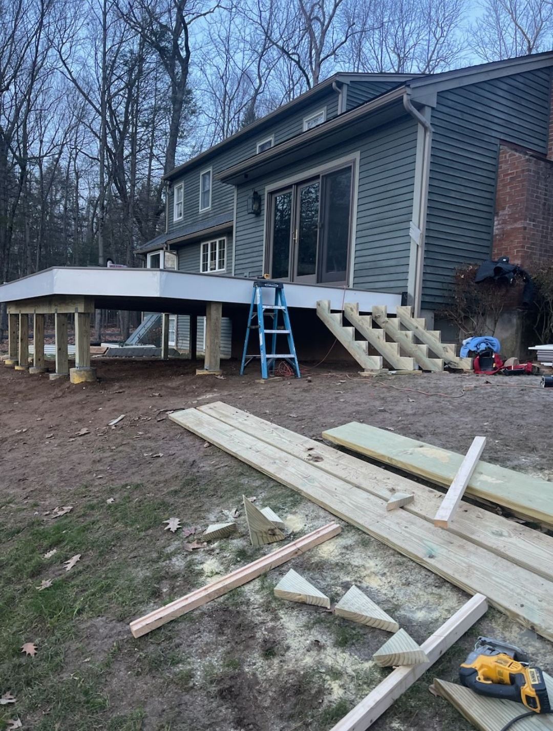 A wooden deck is being built in front of a house.