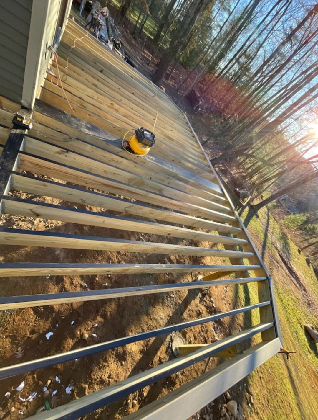 A vacuum cleaner is sitting on top of a wooden deck.