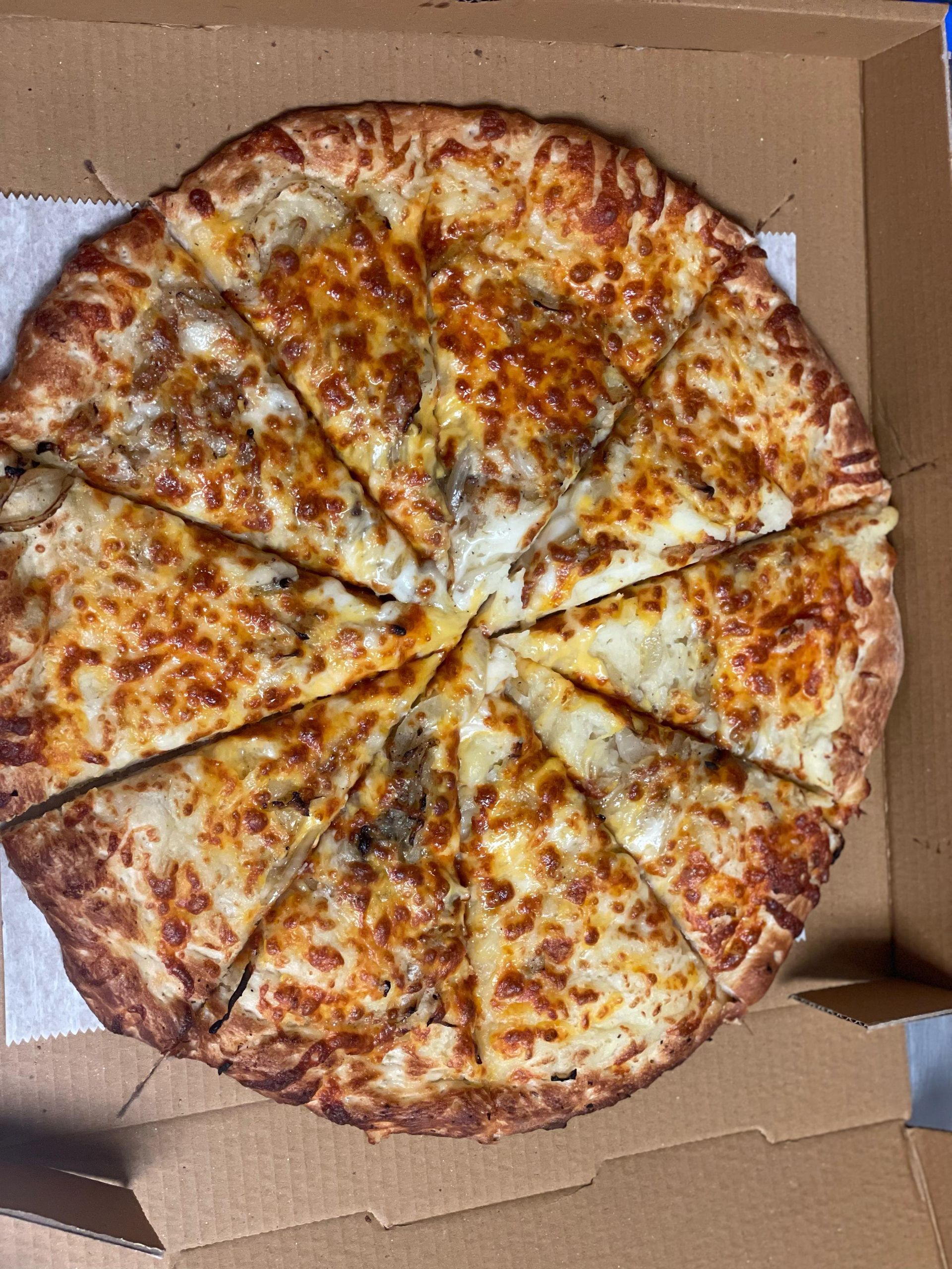 Sliced cheese pizza in a cardboard pizza box.