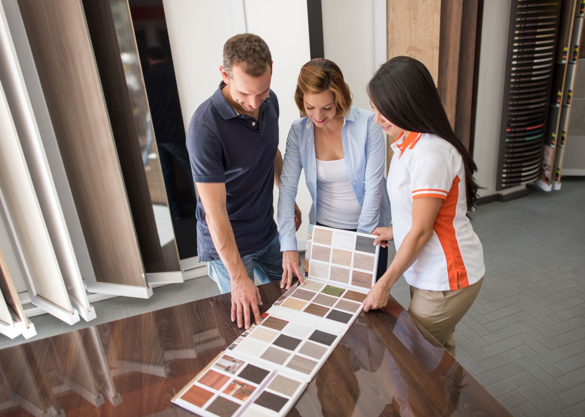 A couple is browsing wood samples at a store, exploring options for flooring sales