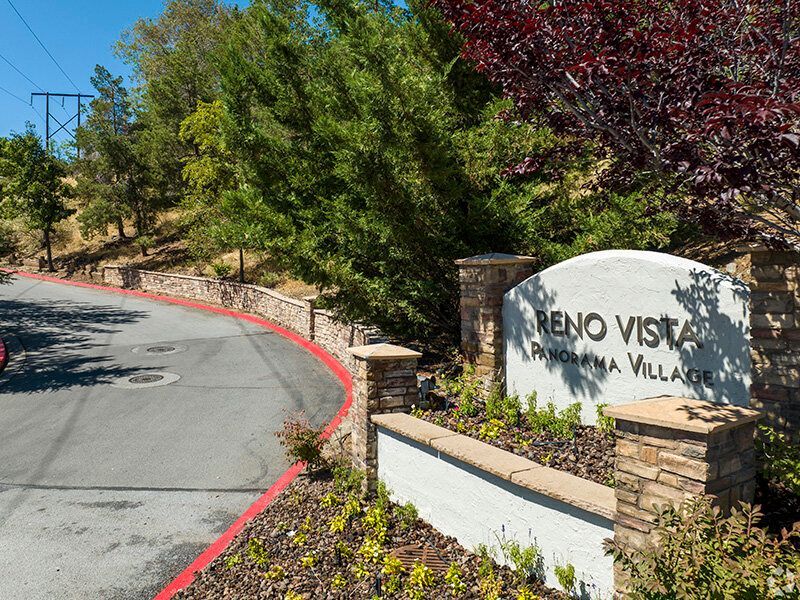 Entrance sign for Reno Vista Panorama Village with landscaped surroundings.