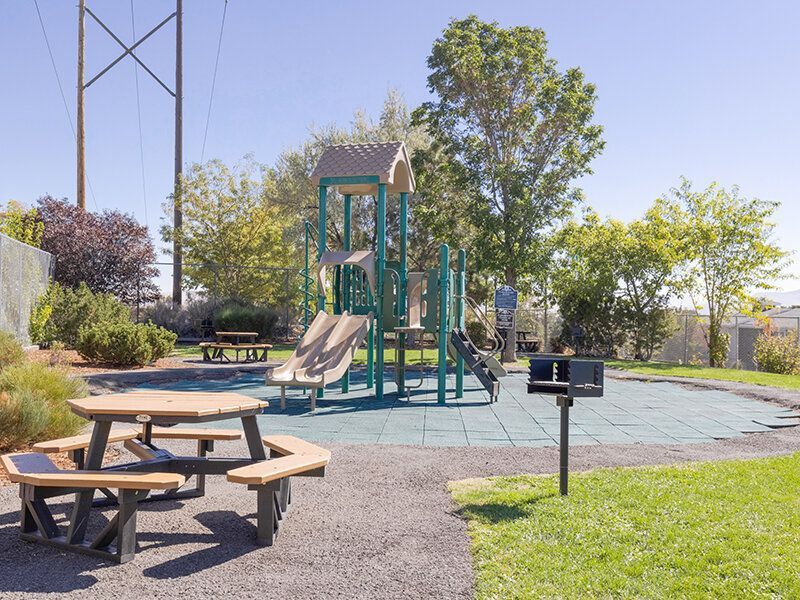 Playground at an apartment community with slides and seating.
