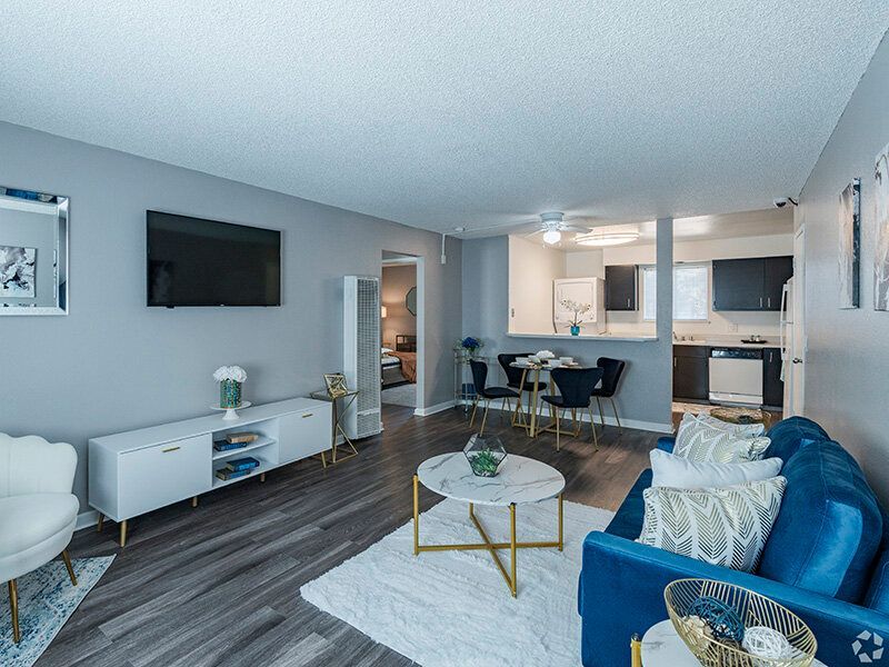 Open-concept living room with TV, sofa, coffee table, and open kitchen.