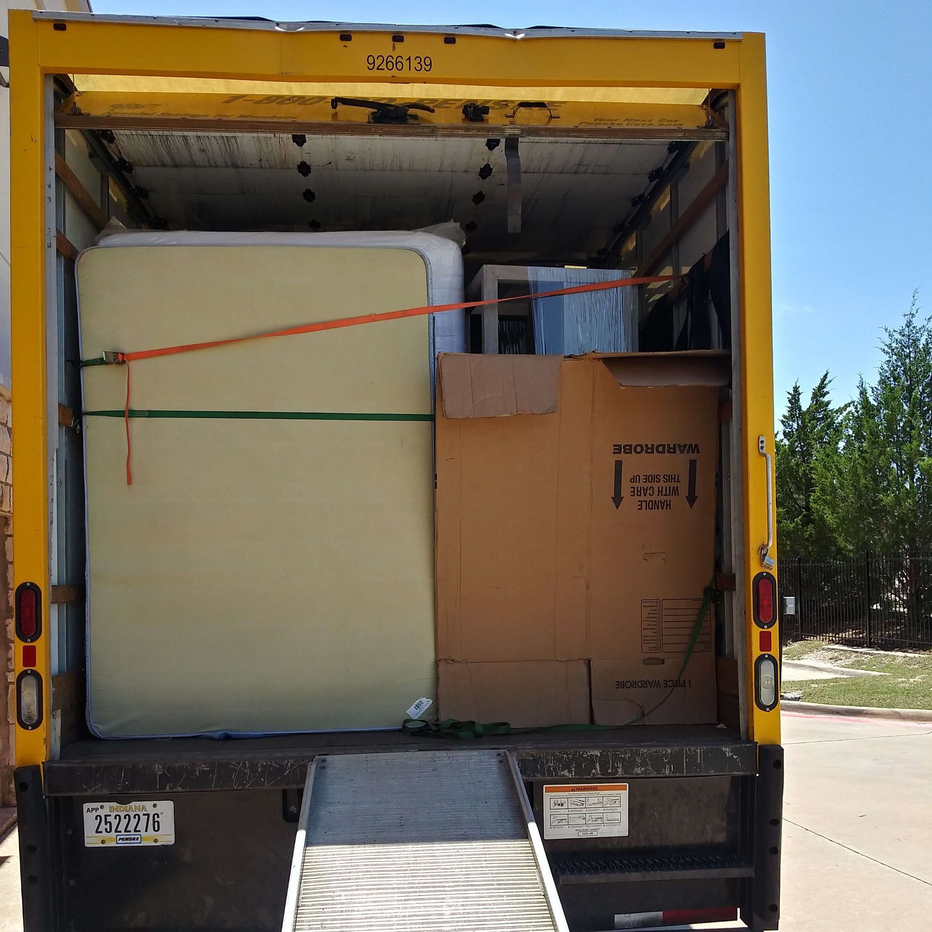 The back of a moving truck with a mattress and boxes