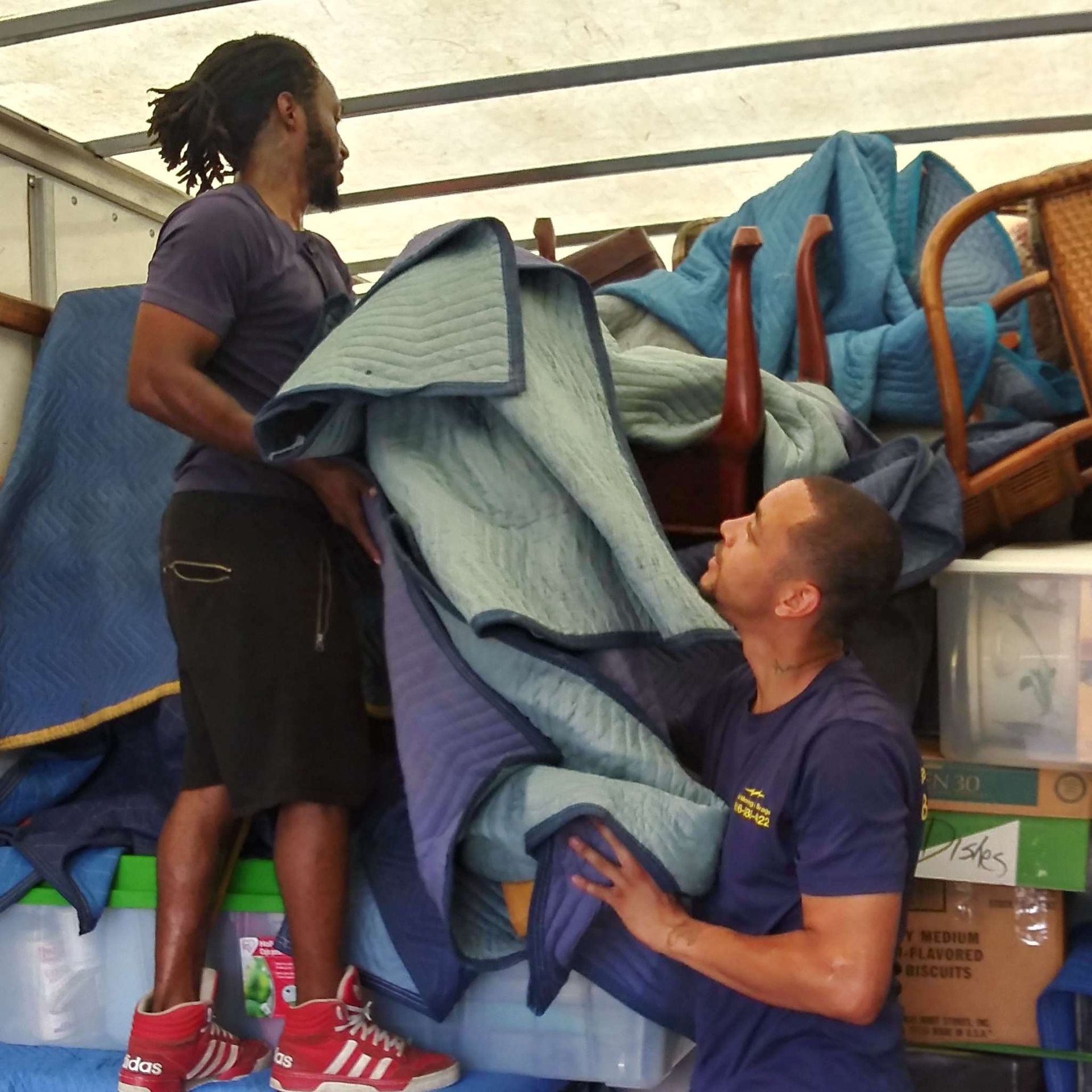 A man in a blue shirt is holding a blue blanket