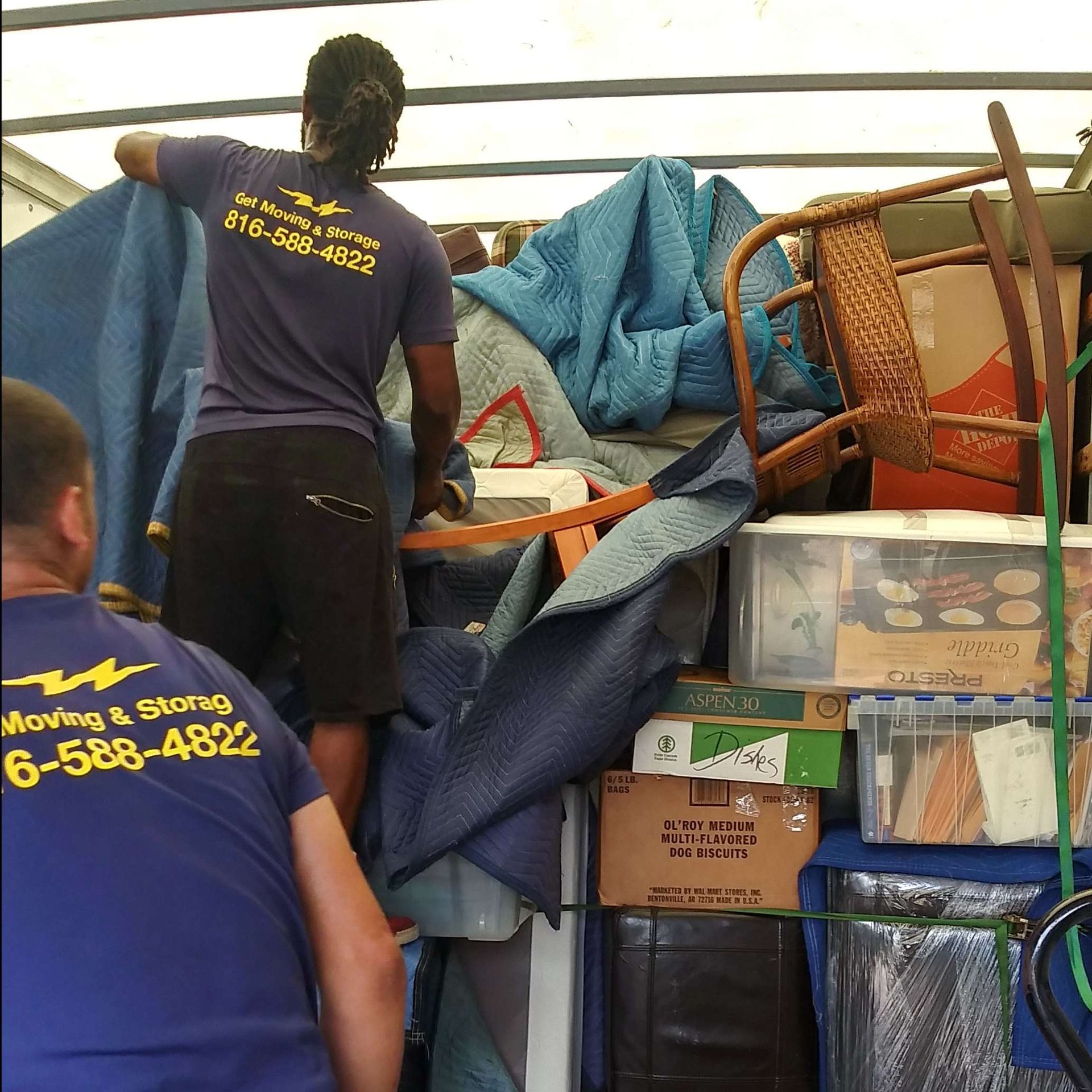 A man wearing a blue shirt that says moving & storage on it
