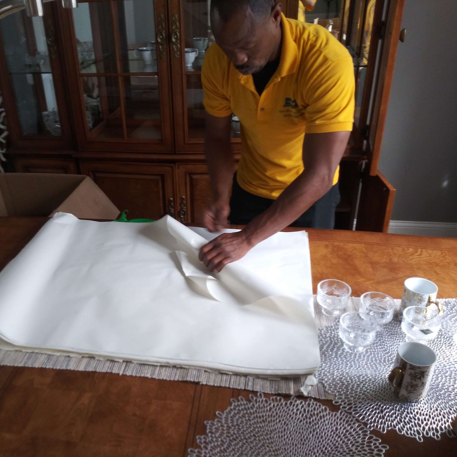 A man in a yellow shirt is working on a piece of paper