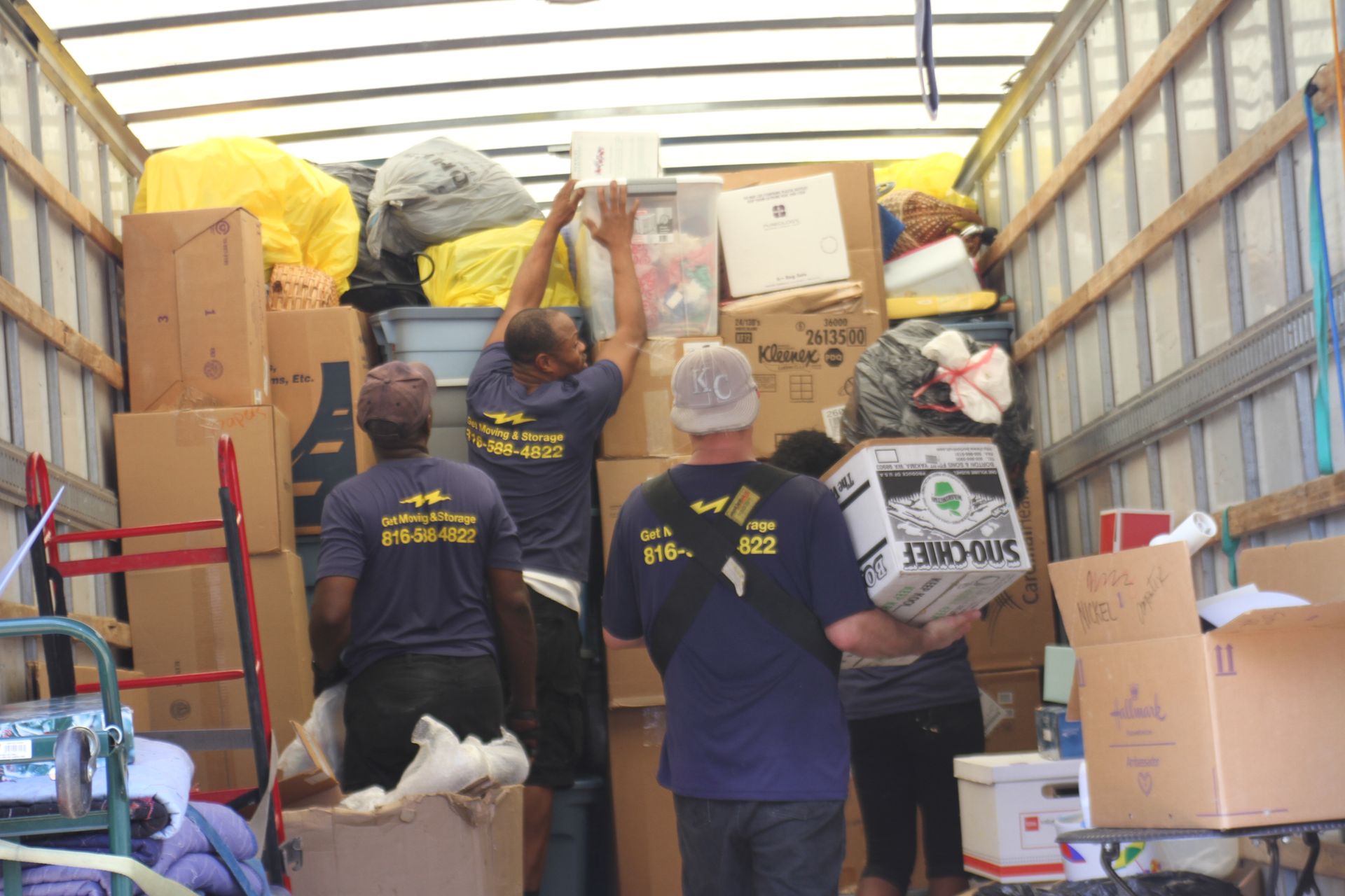 A group of people are loading boxes into a moving truck.