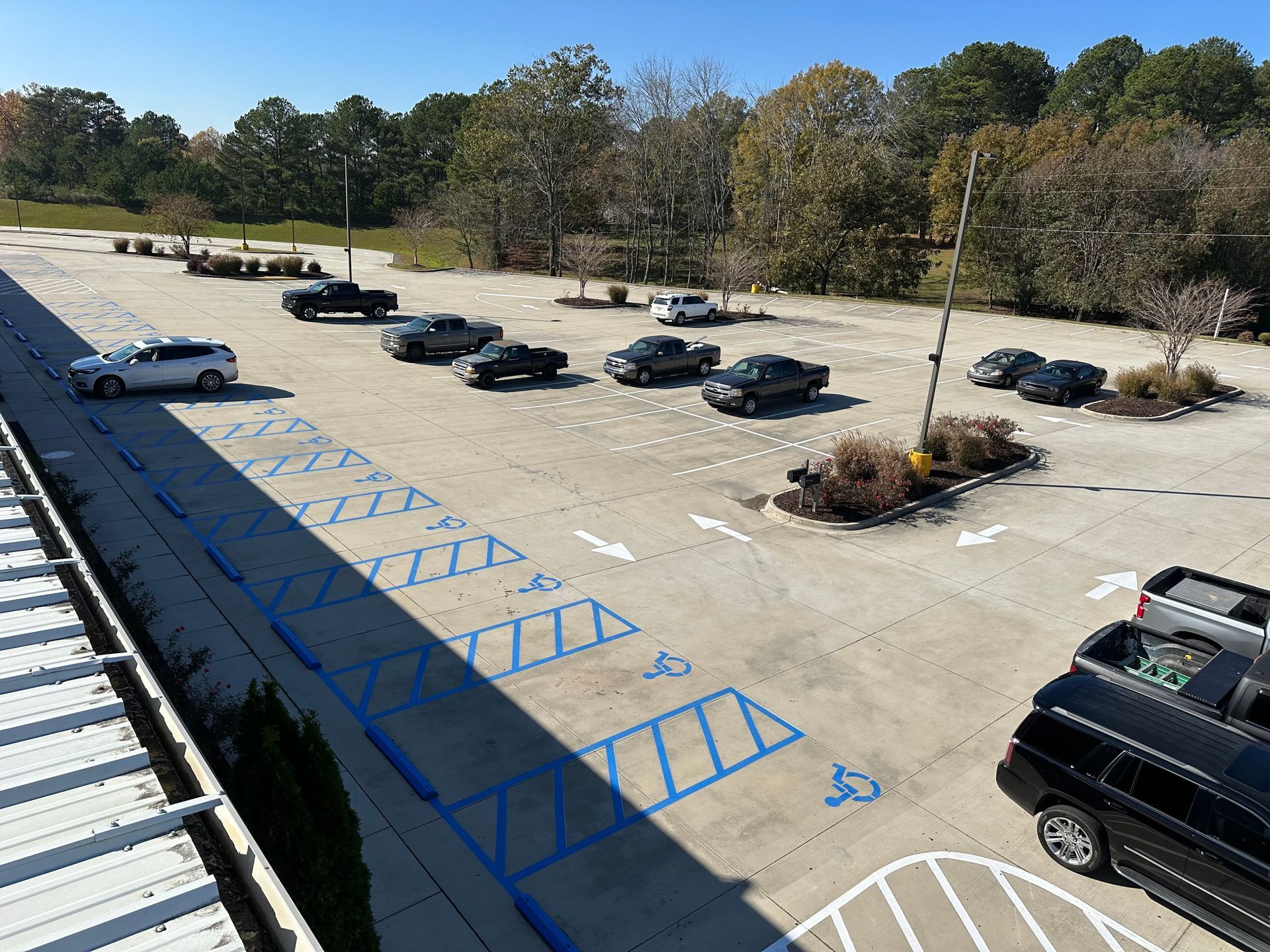 Parking lot with multiple vehicles parked; blue handicap parking spaces are visible.