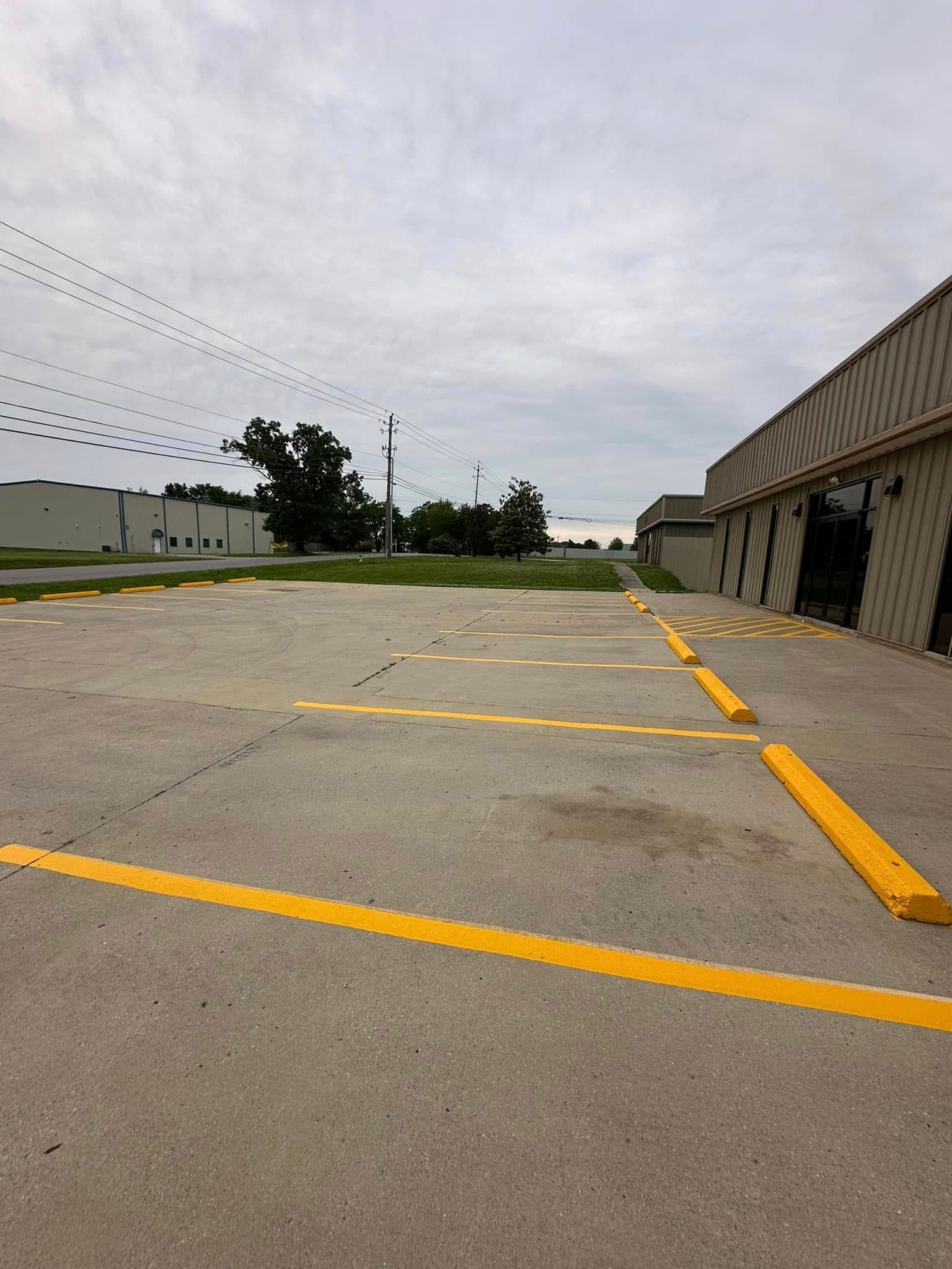 A parking lot with blue handicap spaces, several cars, and yellow and blue lines. Sunny day.