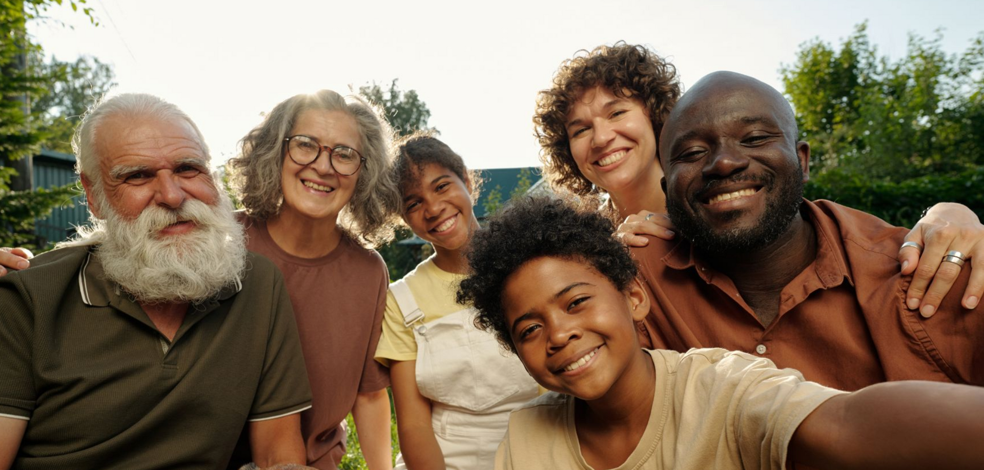 A man , woman and child are hugging each other and smiling.