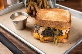 A grilled cheese sandwich and french fries on a tray.