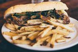 A sandwich and french fries on a white plate.