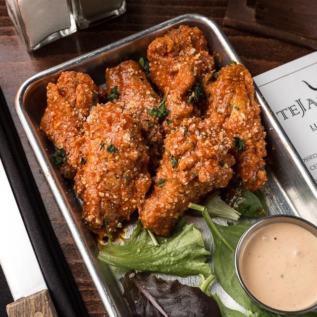 A tray of chicken wings with a side of ranch dressing