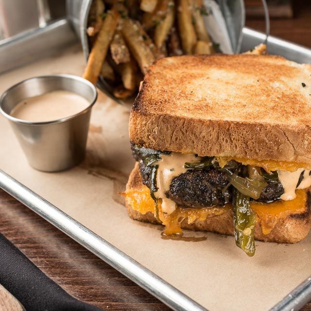 A grilled cheese sandwich and french fries on a tray