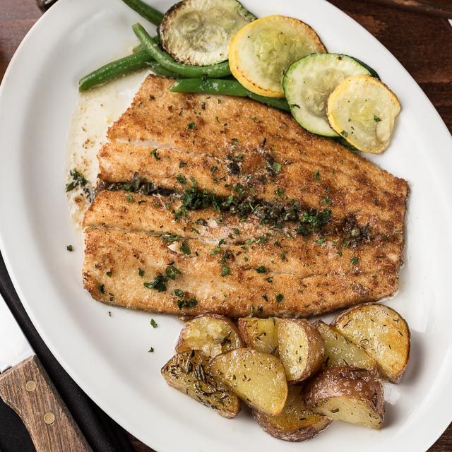 A white plate topped with meat potatoes and vegetables