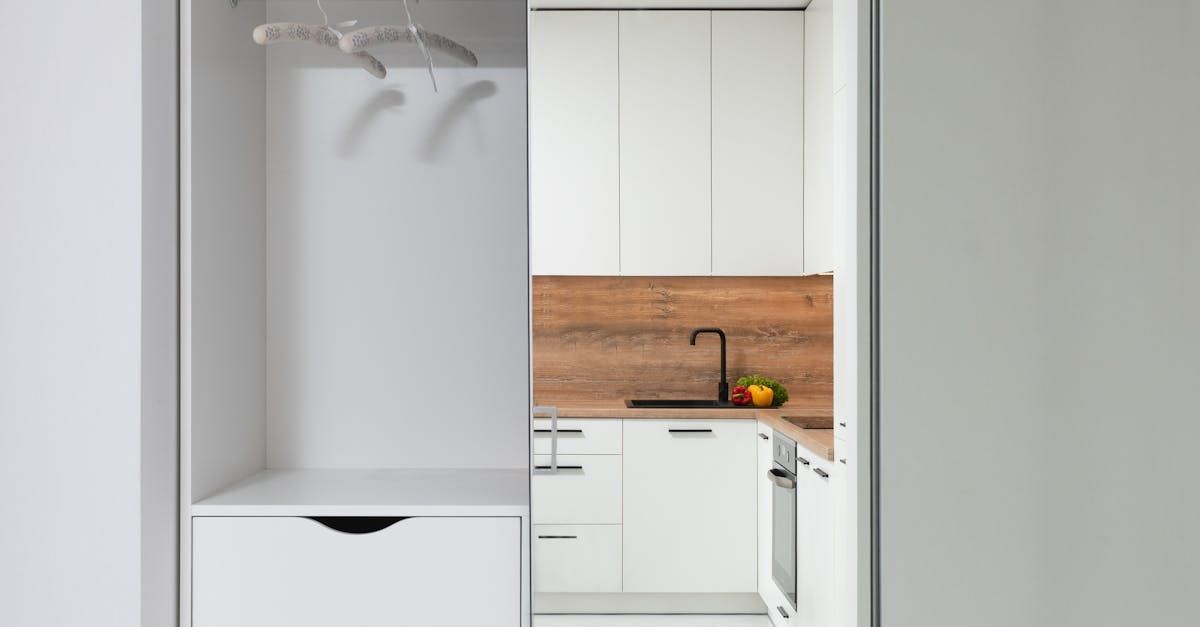 A kitchen with white cabinets and a wooden counter top.
