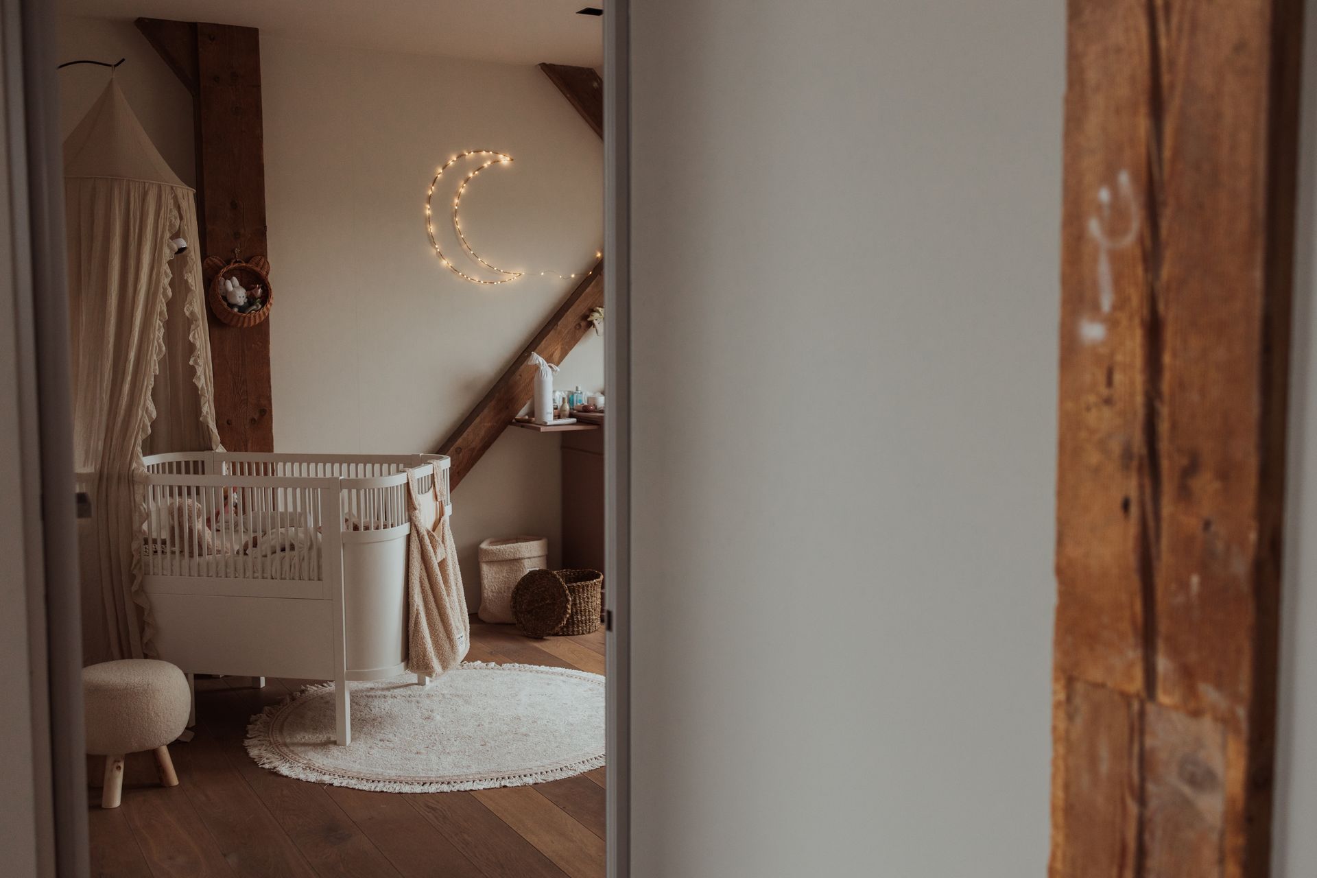 Een babykamer met een ledikantje en een hemeltje.