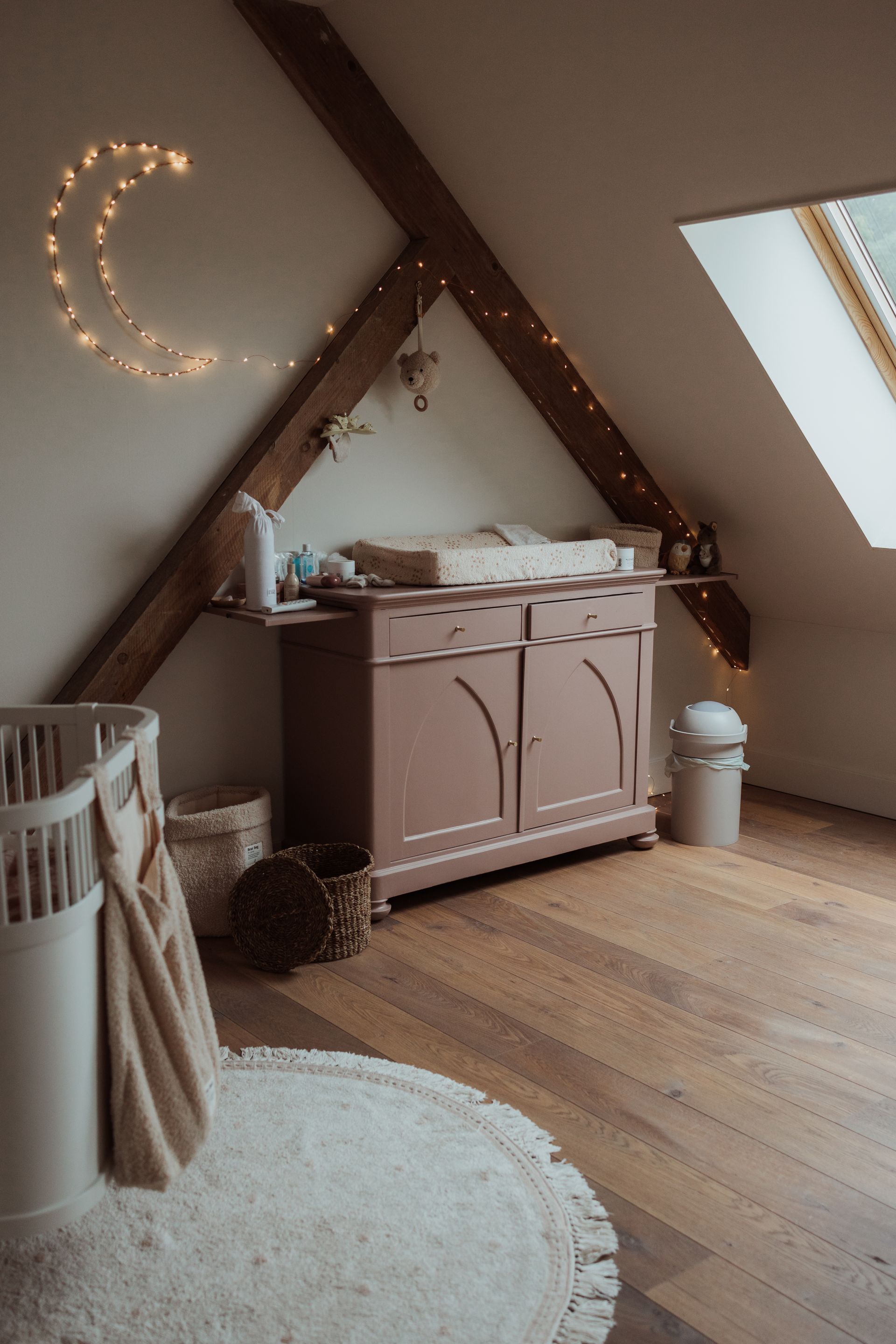 Een babykamer met een kinderbedje, commode en verschoontafel.