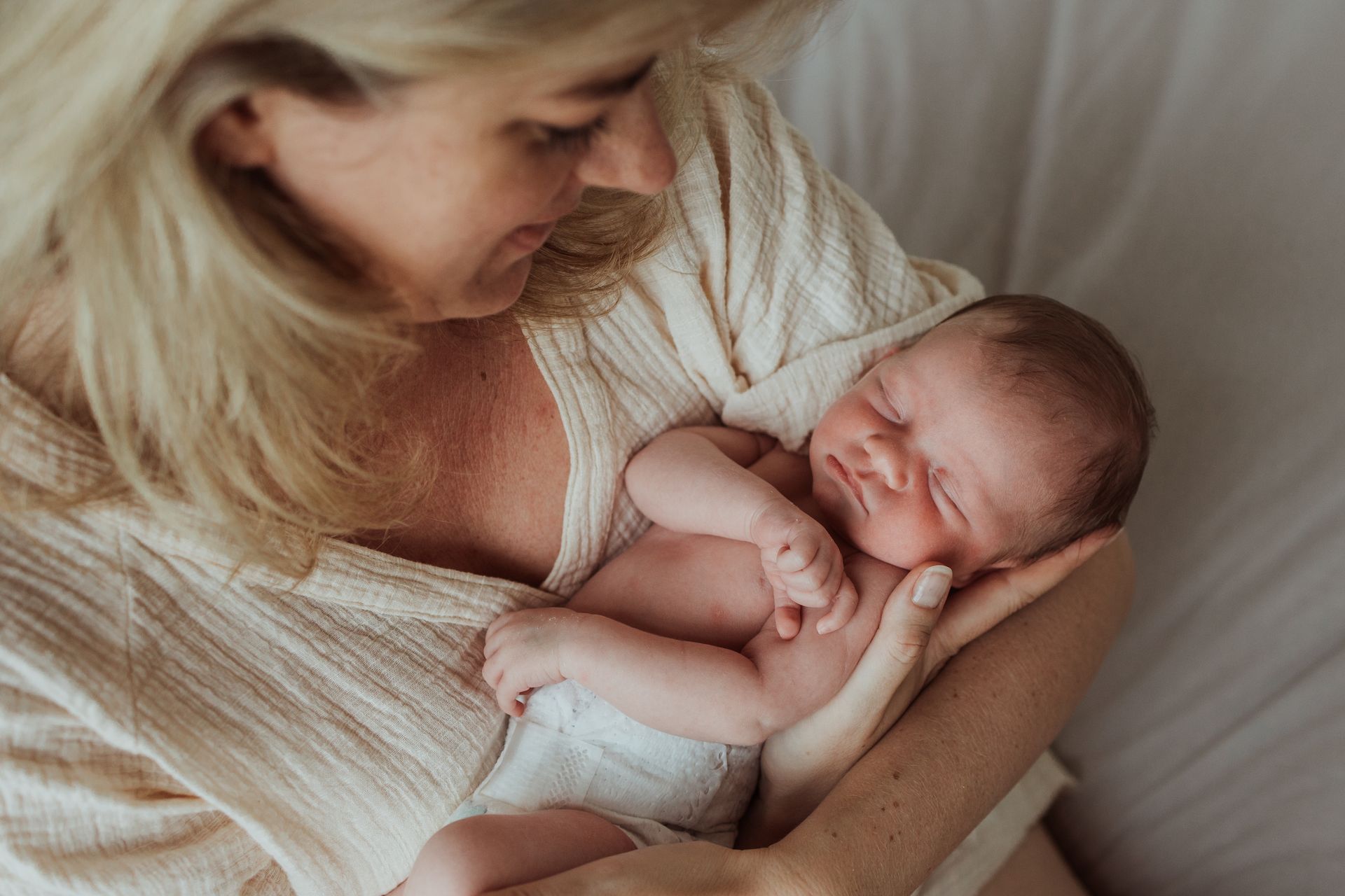 Een vrouw houdt een pasgeboren baby in haar armen.