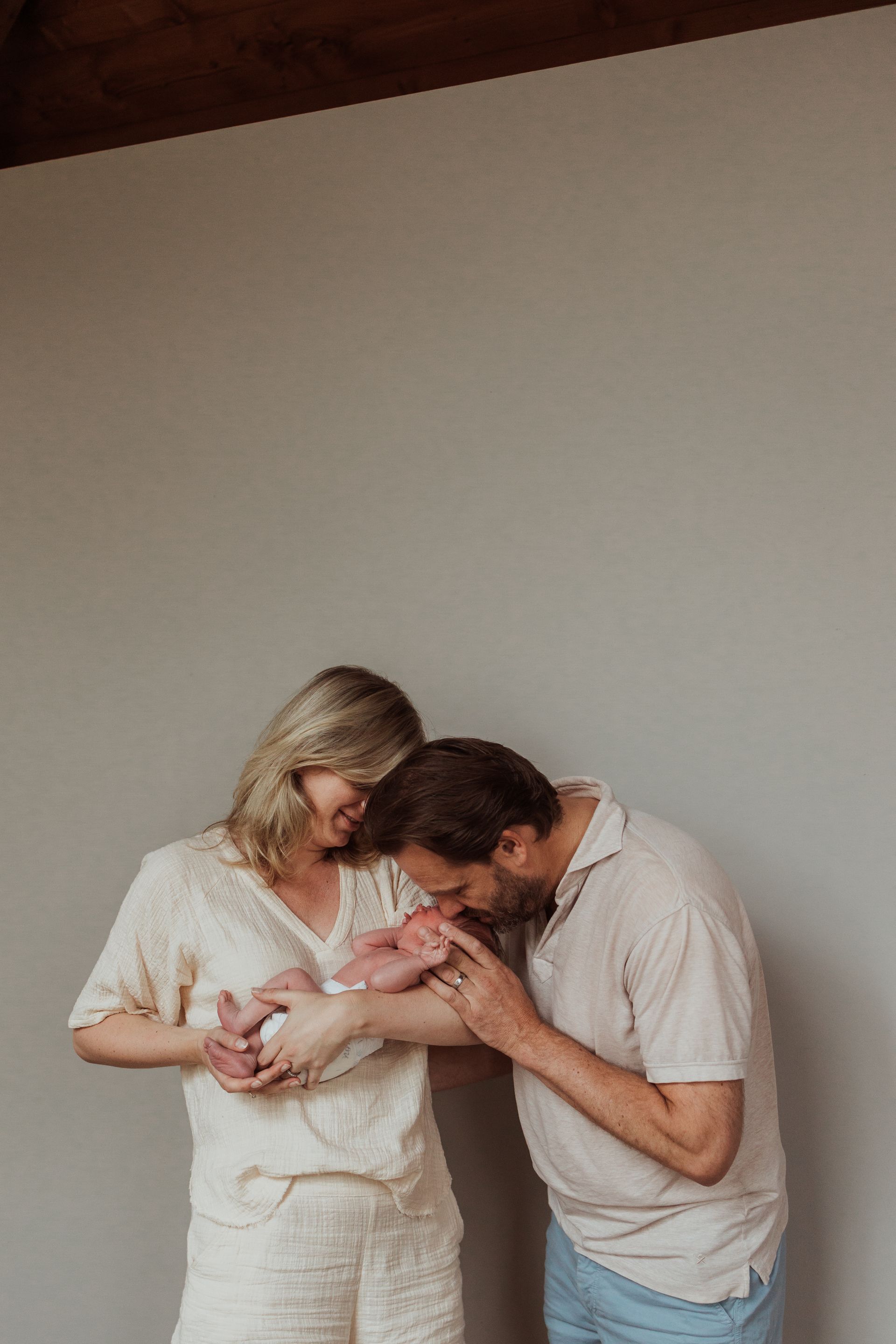 Een man en een vrouw houden een pasgeboren baby in hun armen.