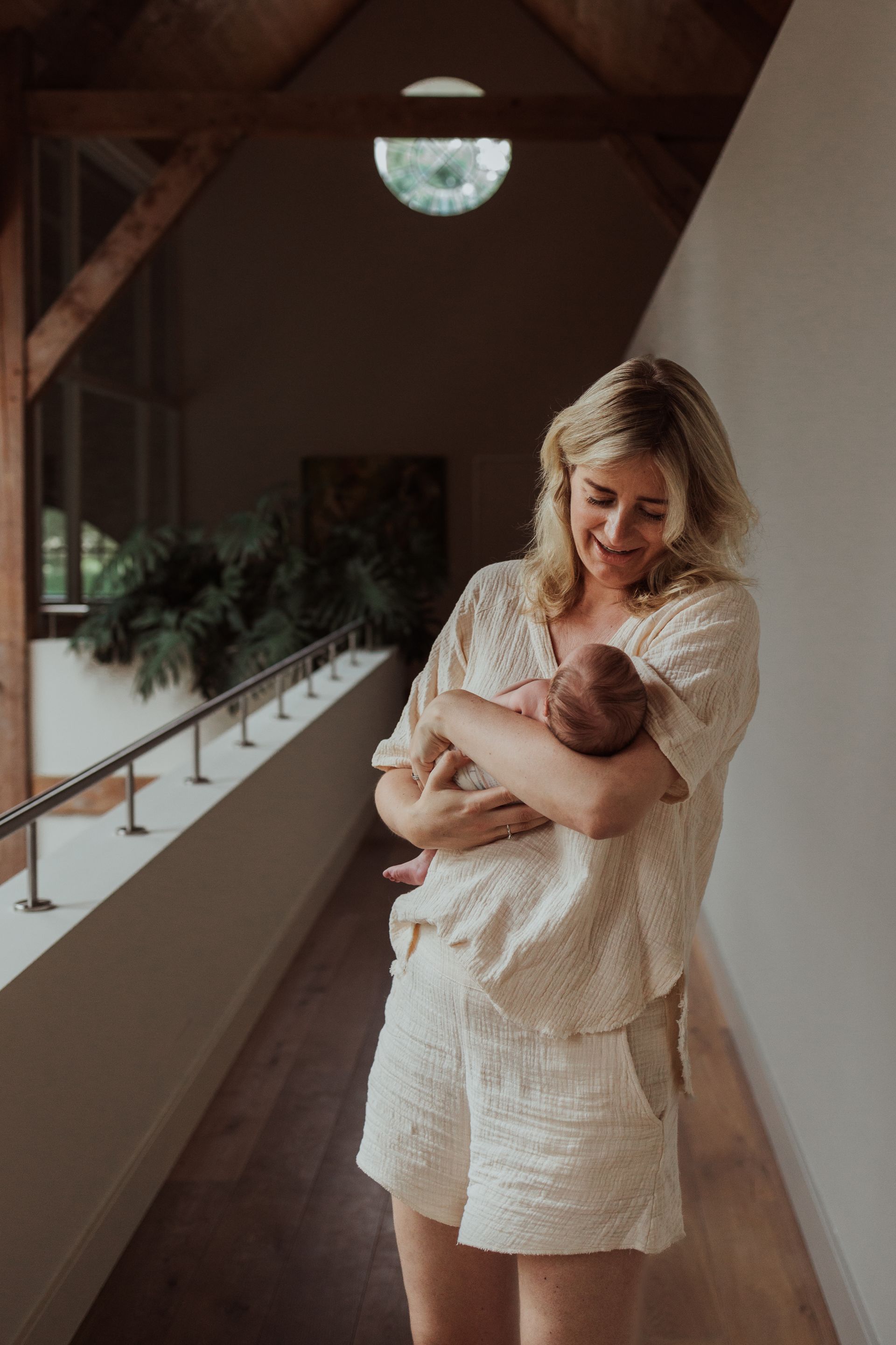 Een vrouw houdt een baby in haar armen in een gang.