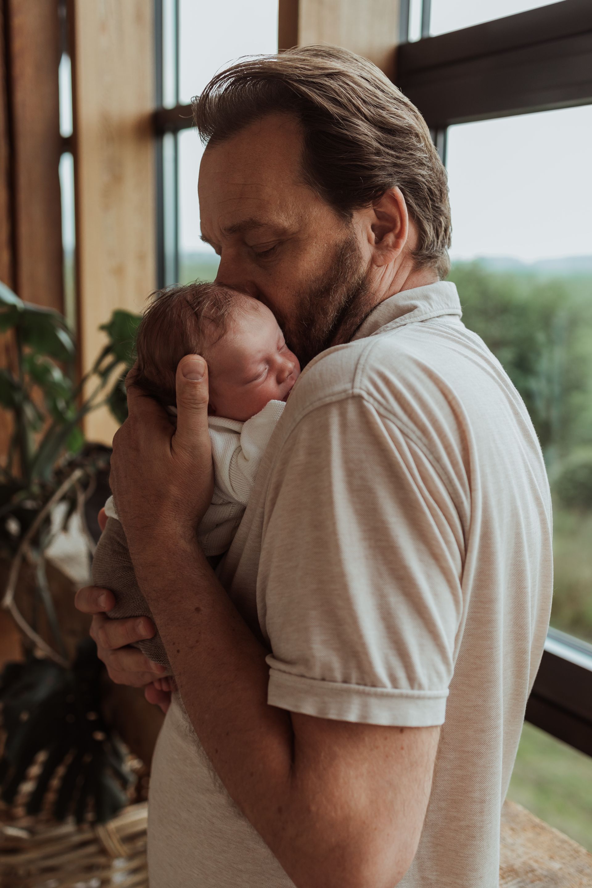 Een vader houdt zijn pasgeboren baby in zijn armen.