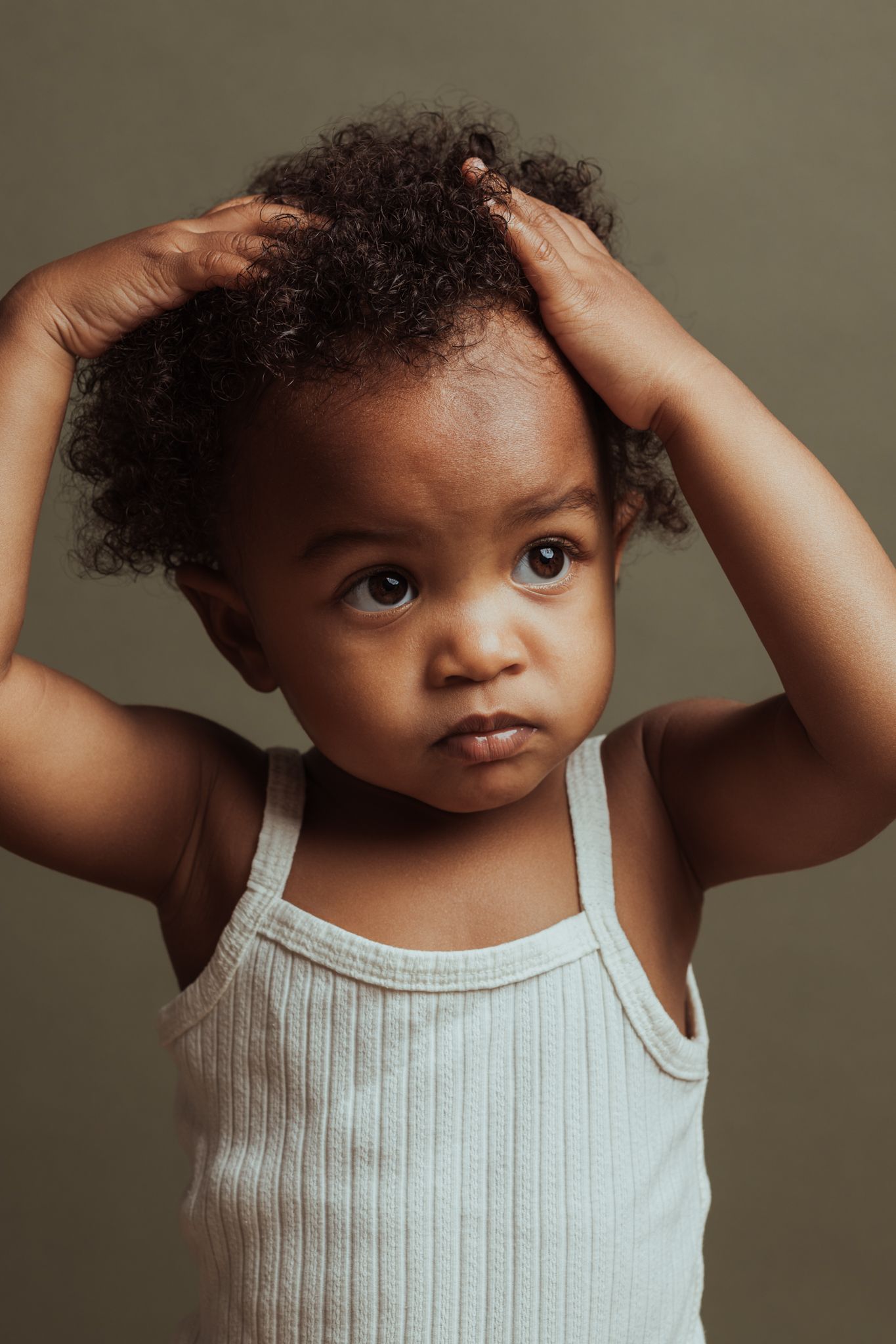 Kinderportret van meisje met de handjes in het haar