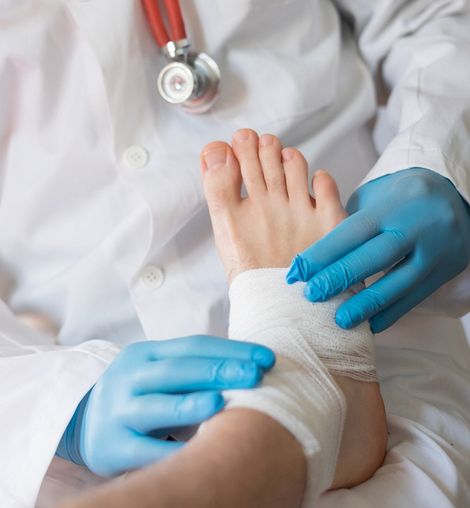 Doctor Bandaging Injured Foot — Longmeadow, MA — Dr. Christopher H. Peteros, DPM, LLC