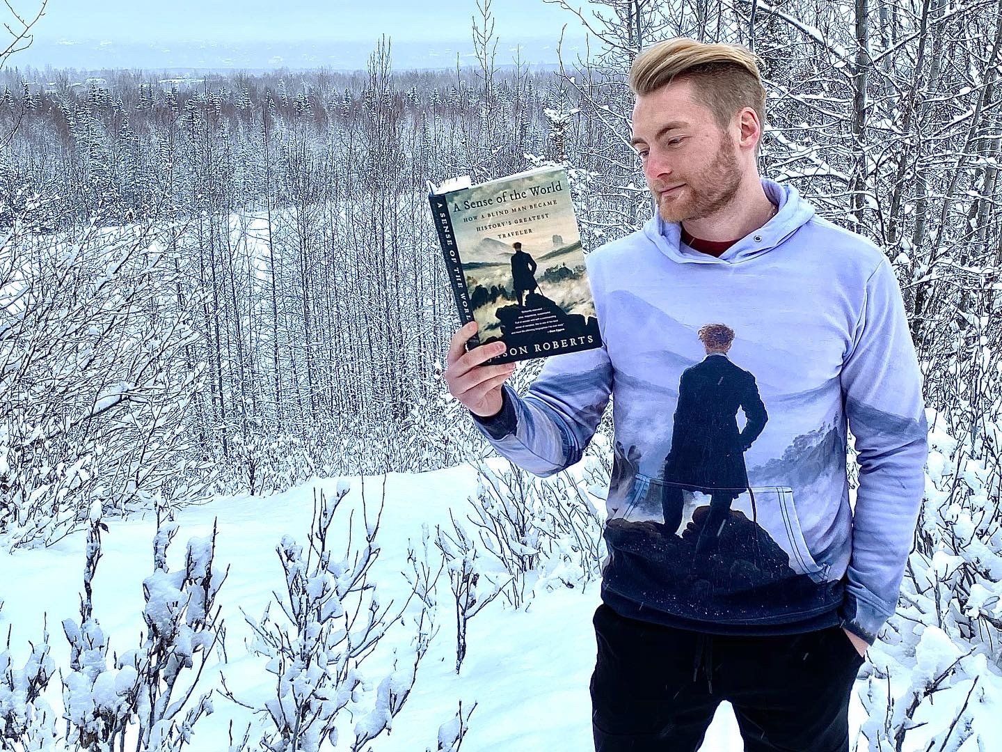 Xander Clemens in Anchorage, Alaska in University Lae Dog Park with the book