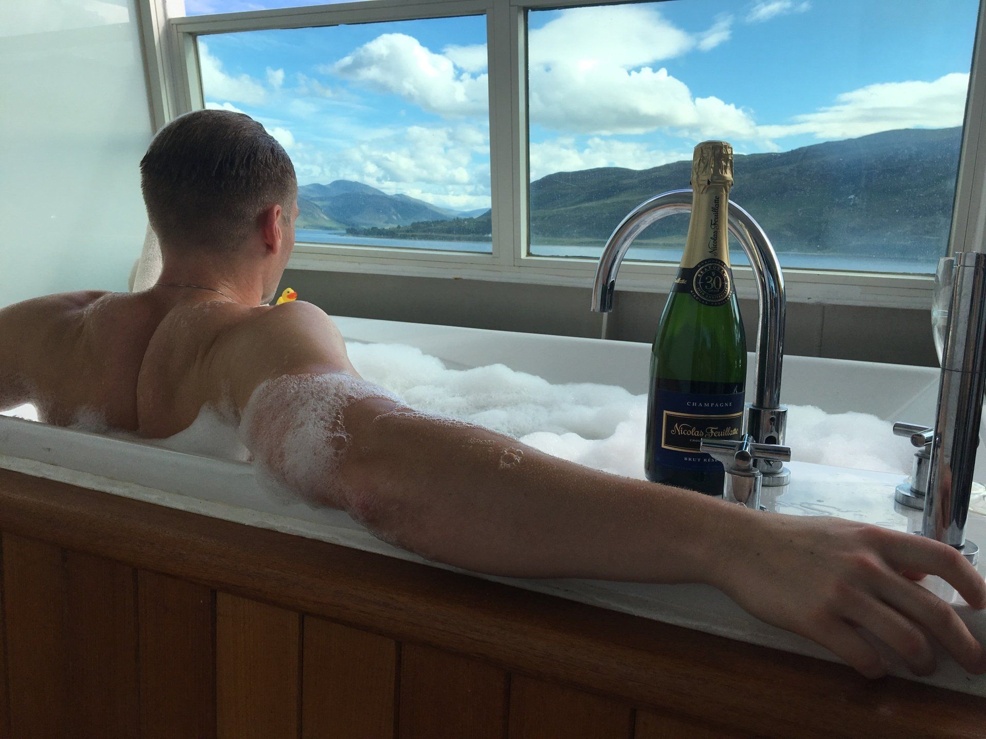 Xander Clemens on the Seabourn Questin the jacuzzi watching the ocean and mountains.