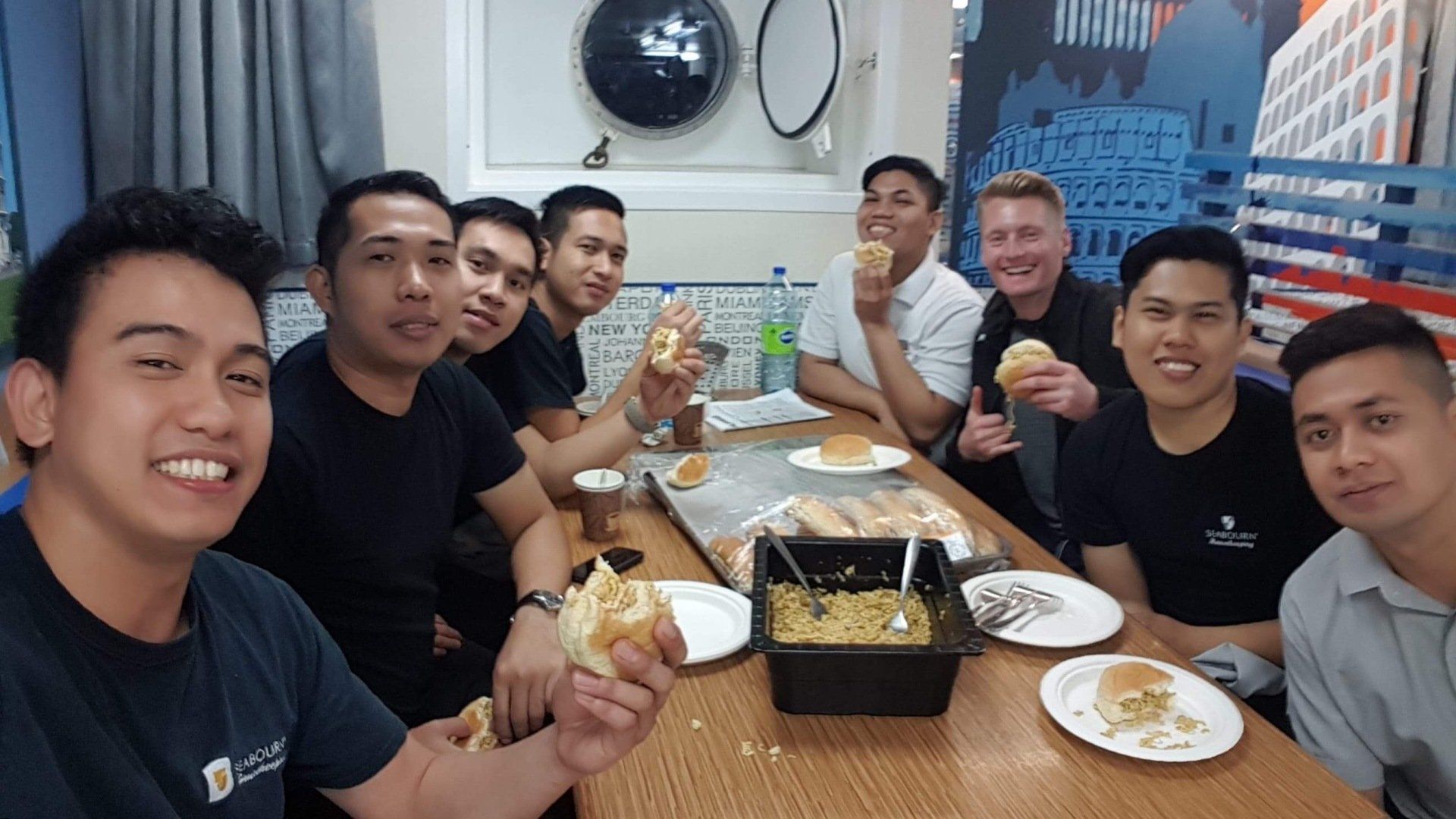 Xander Clemens in the crew mess of the Seabourn Quest with crew members.