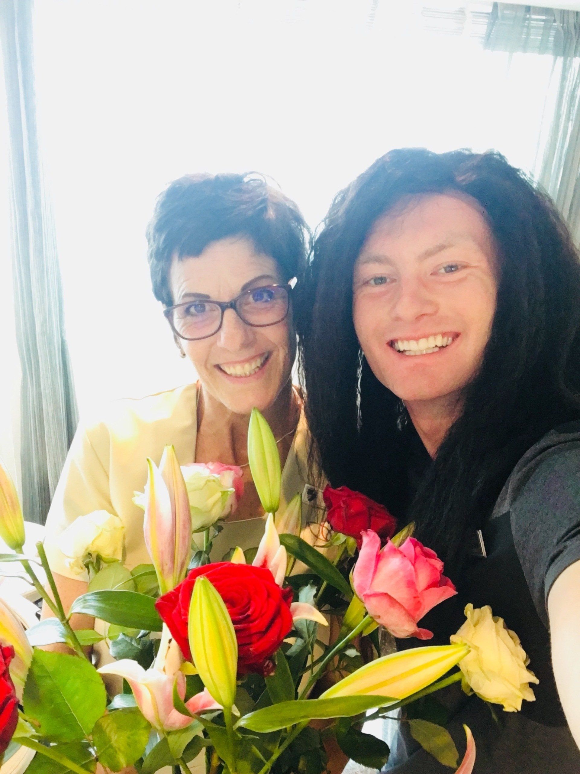 Xander Clemens being silly with Sonja van Wyk holding flowers