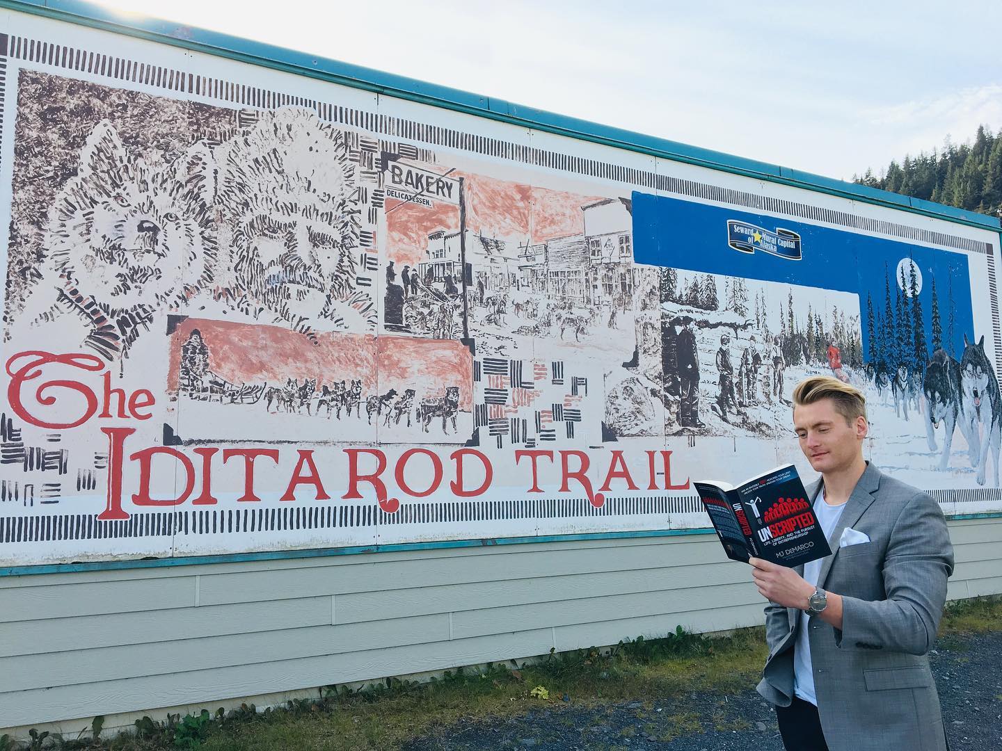 Xander Clemens is in Seward, Alaska reading the book Unscripted Life, Liberty, and the Pursuit of Entrepreneurship by MJ DeMarco