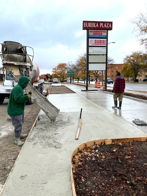 A Concrete Mixer Truck Is Pouring Concrete On A Construction Site - Southgate, MI - Cassino Construction & Cement Corporation