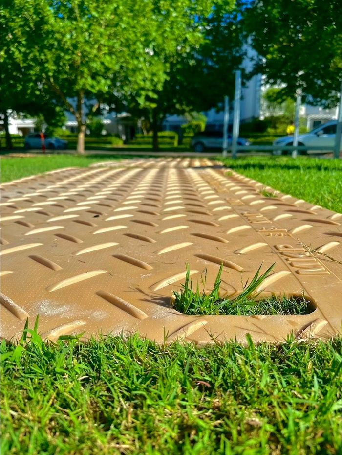 Image of Track mats lay out over some uneven ground.