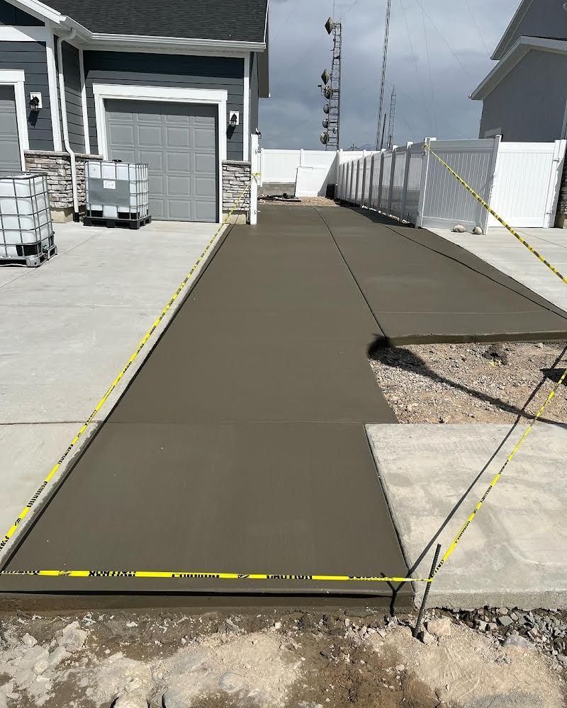 A concrete driveway is being built in front of a house.