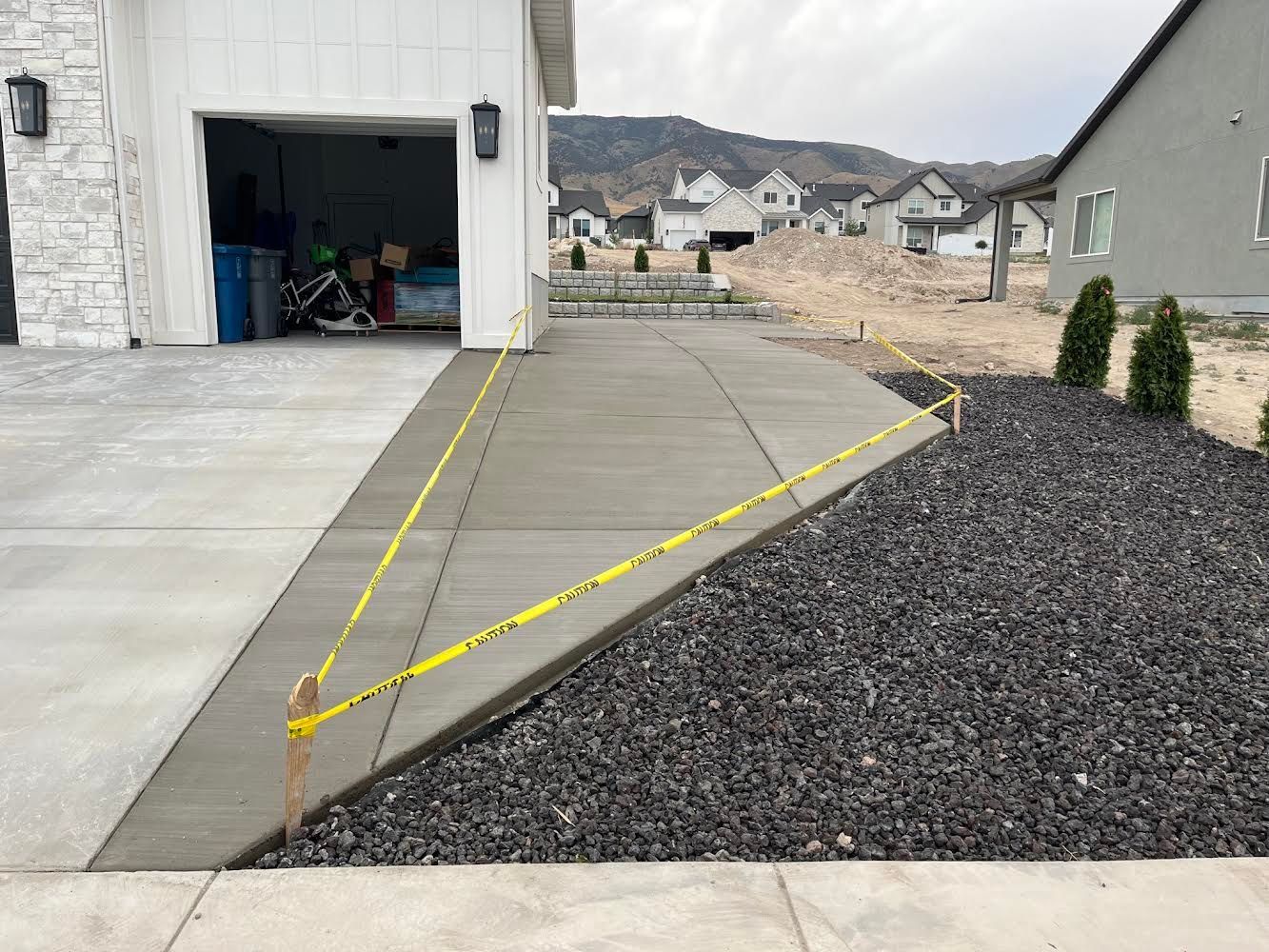 A concrete driveway is being built in front of a house.