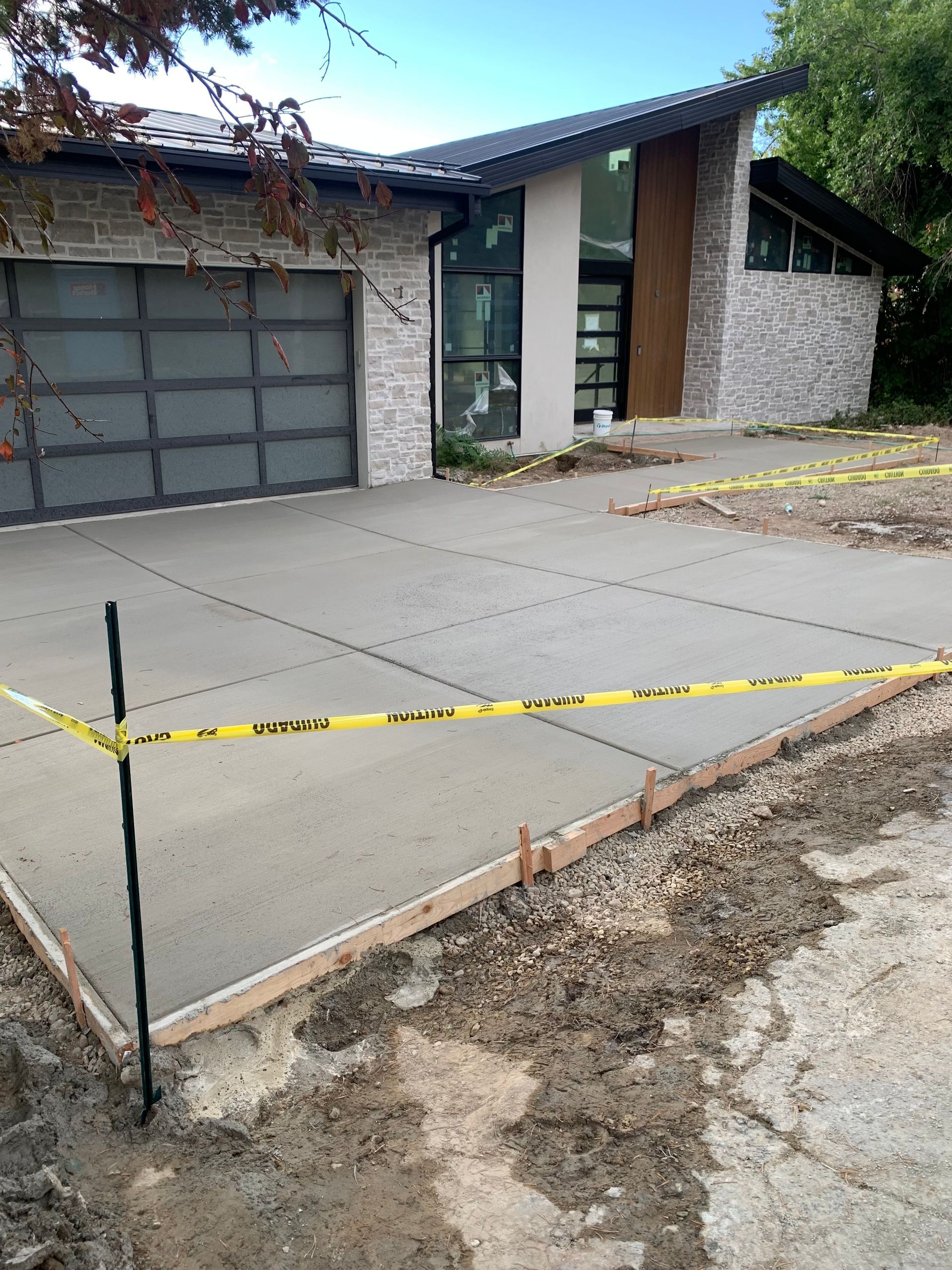 A concrete driveway is being built in front of a house.
