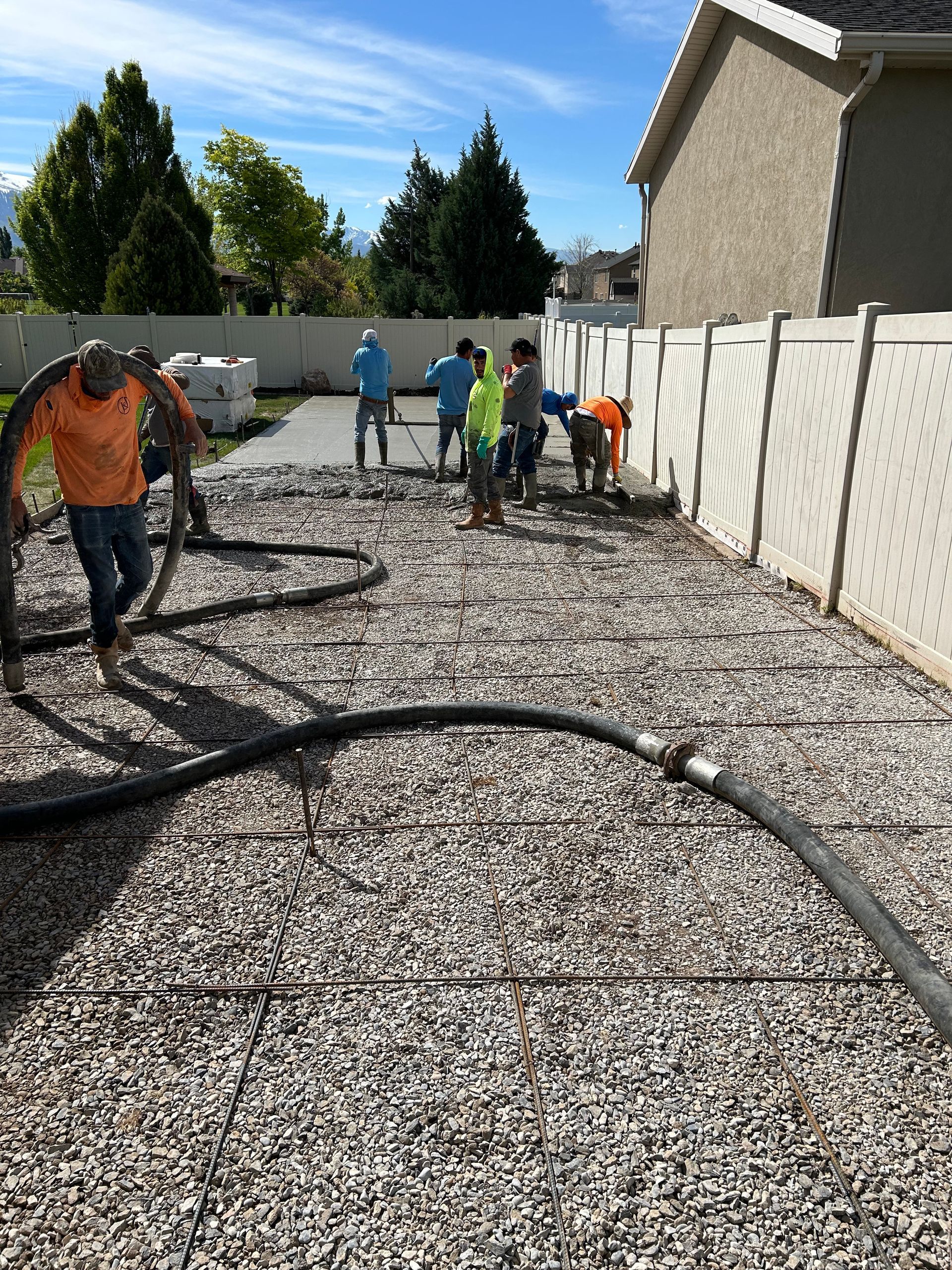 A group of men are working on a gravel driveway