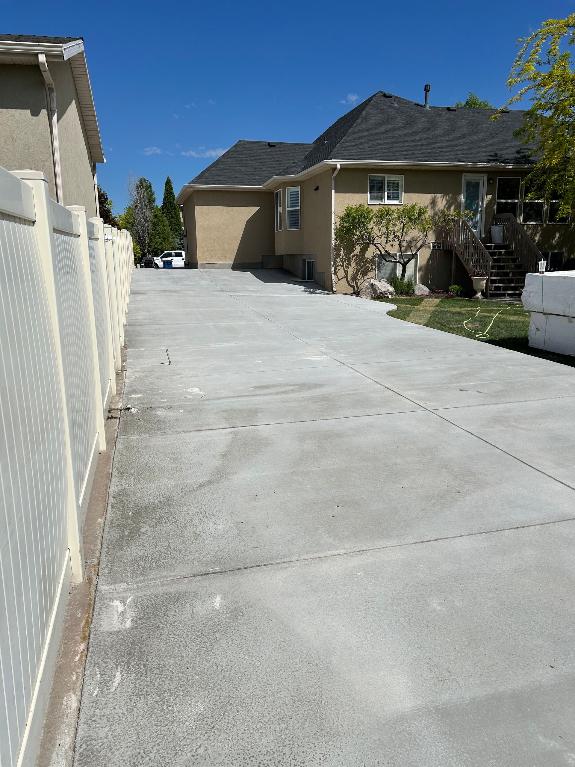 A concrete driveway leading to a house on a sunny day