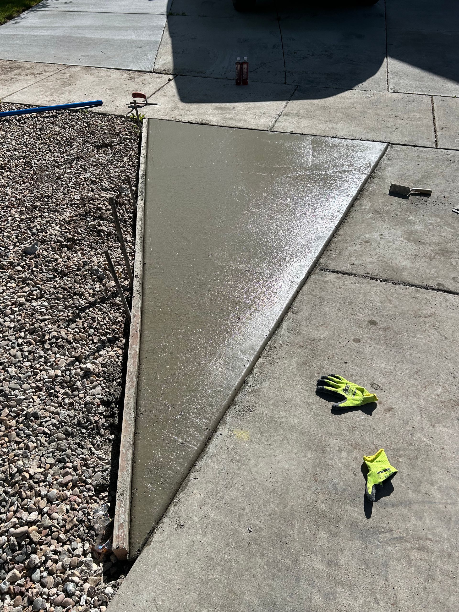 A concrete sidewalk is being built next to a gravel area.