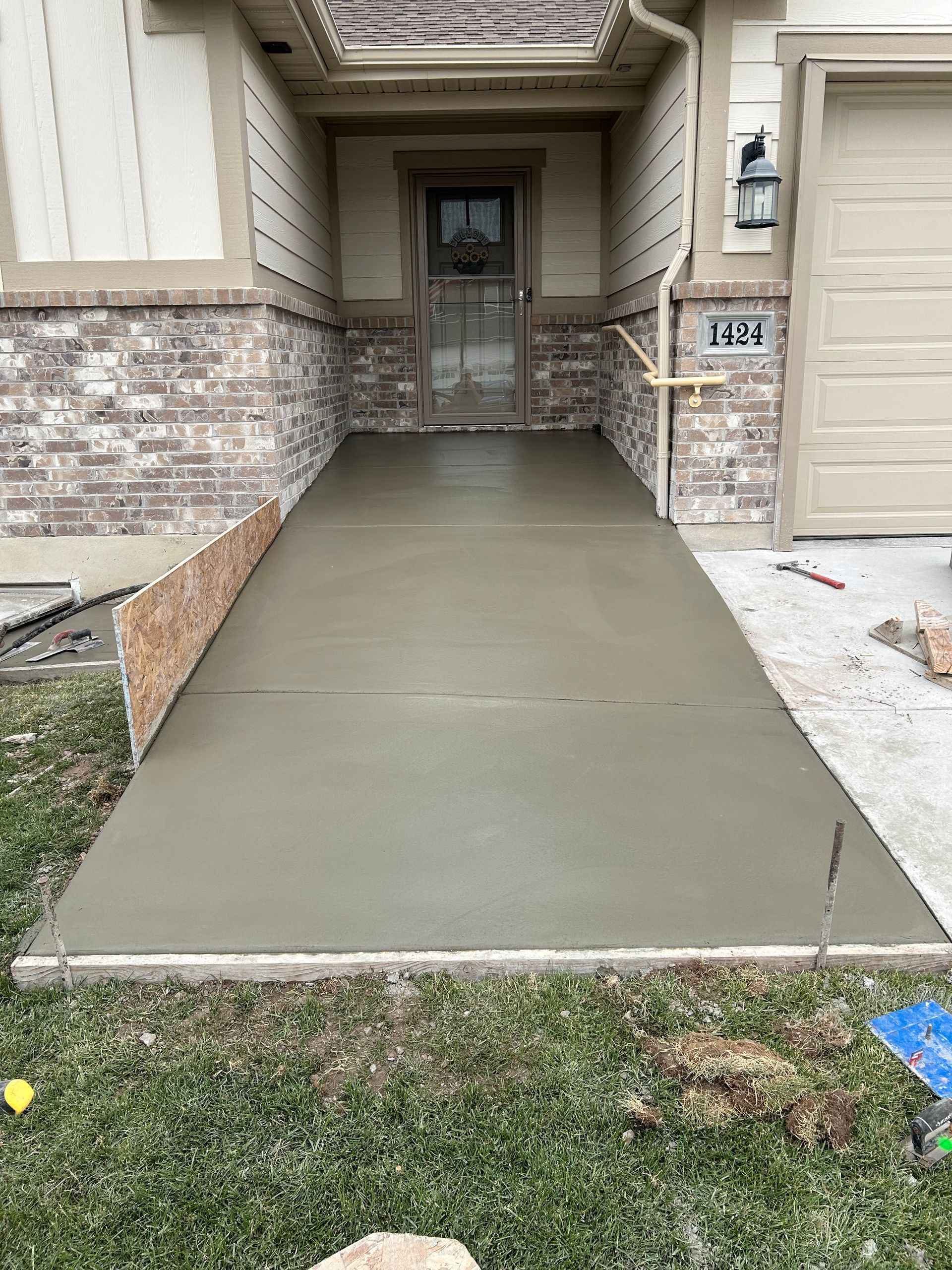 A concrete walkway is being built in front of a house.