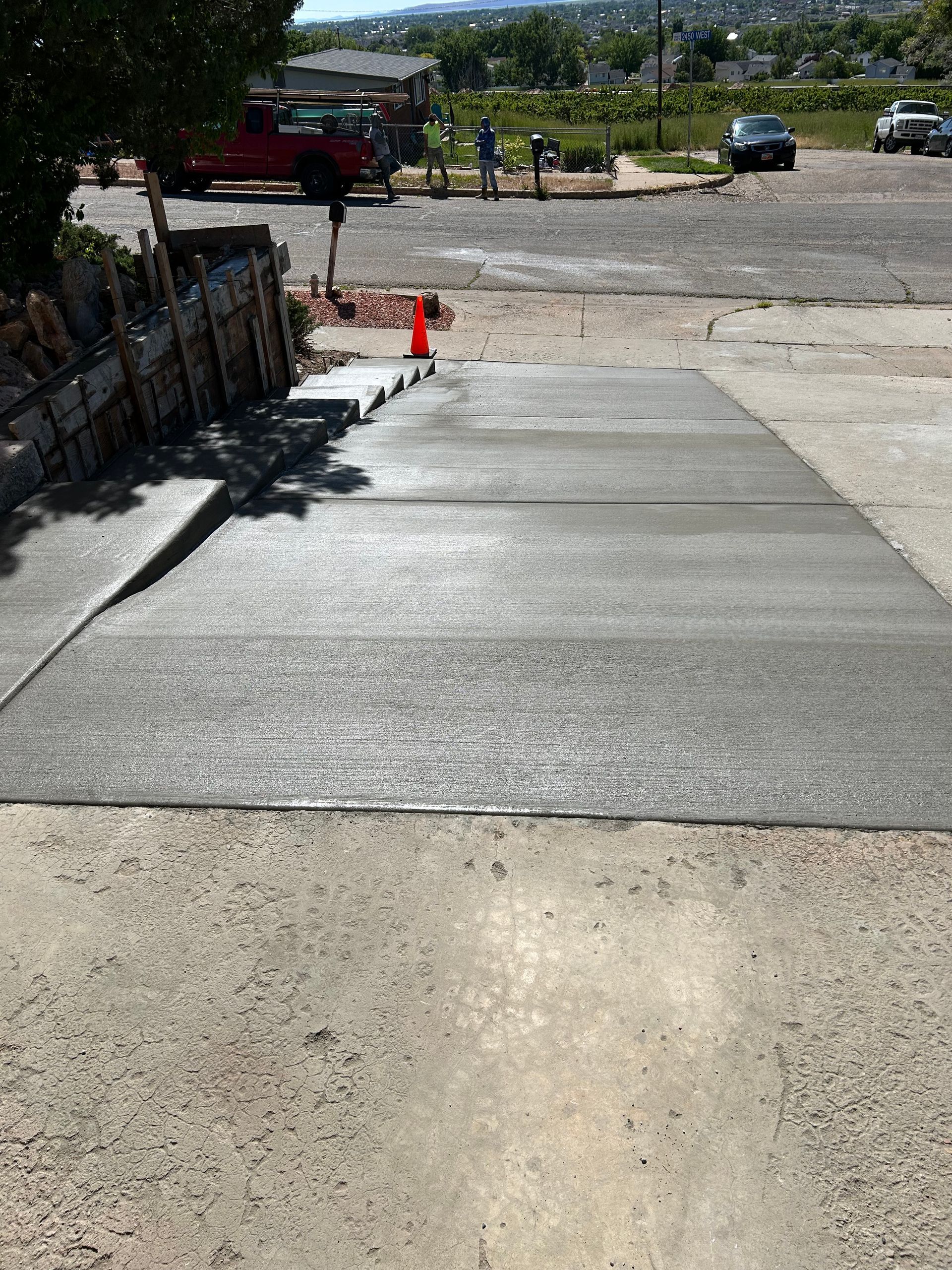 A concrete driveway with a red truck in the background