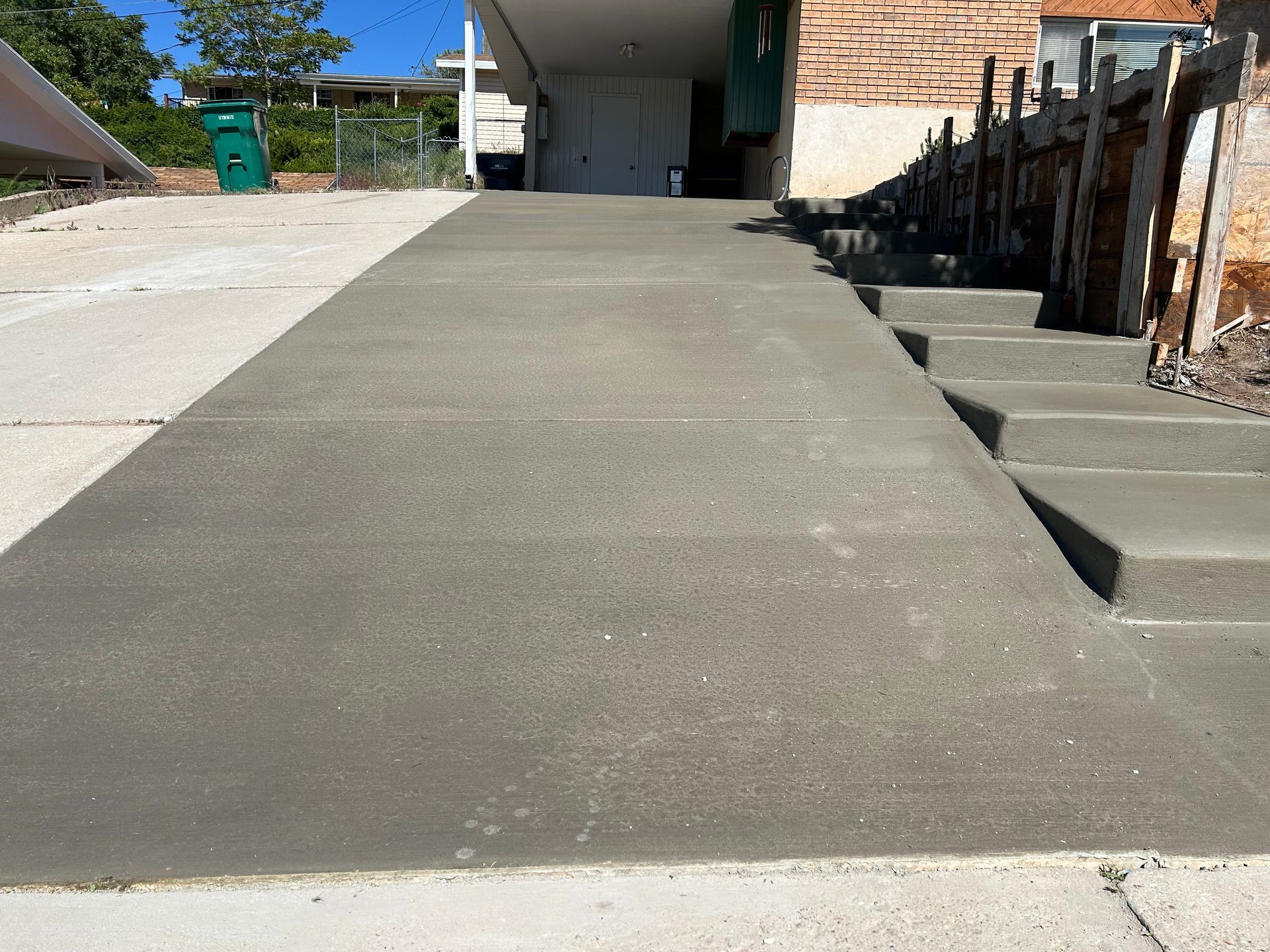 A concrete walkway with stairs leading up to a house